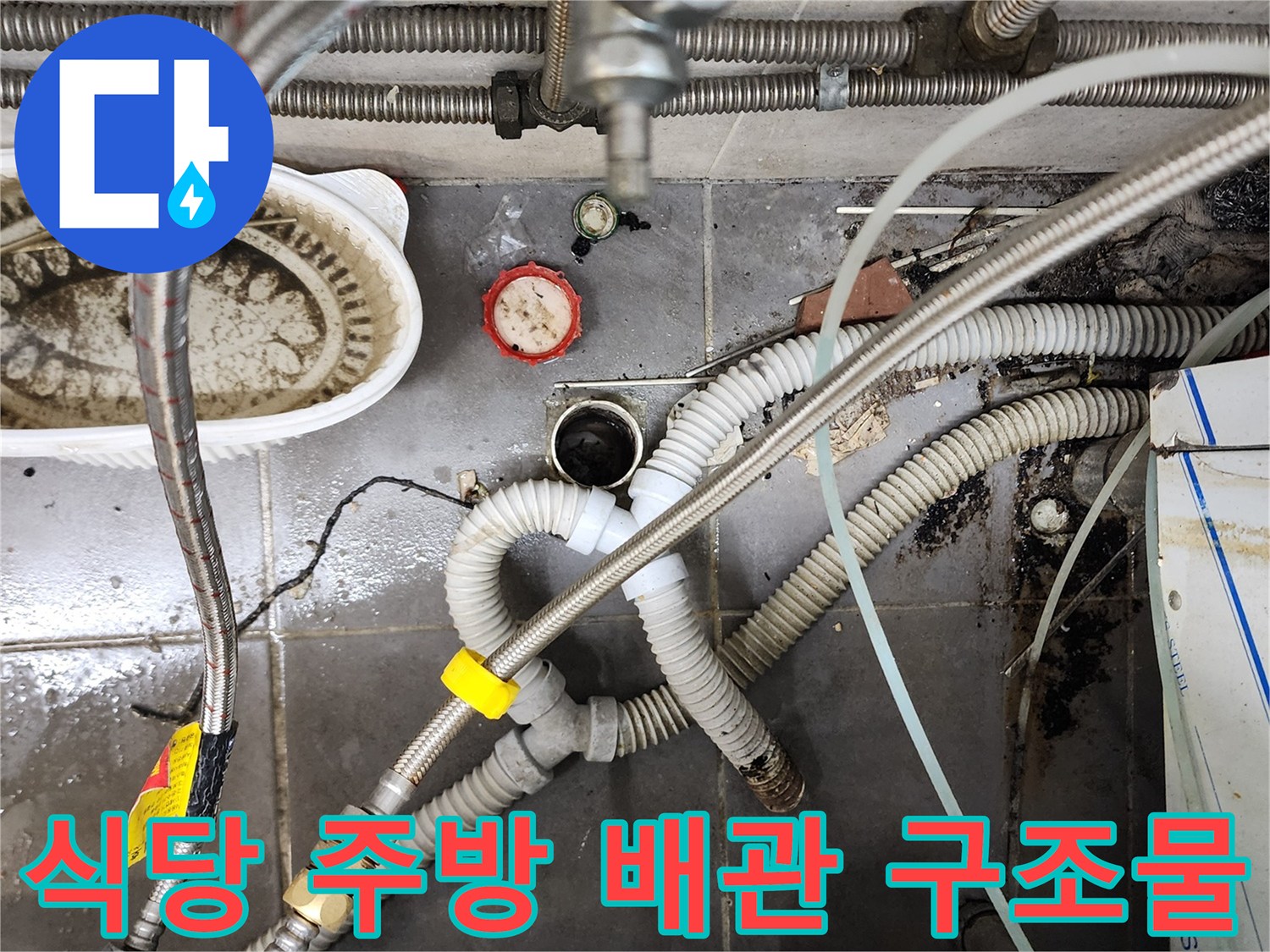 복잡한 형태의 주방용 배수 호스와 금속 연결관 부위