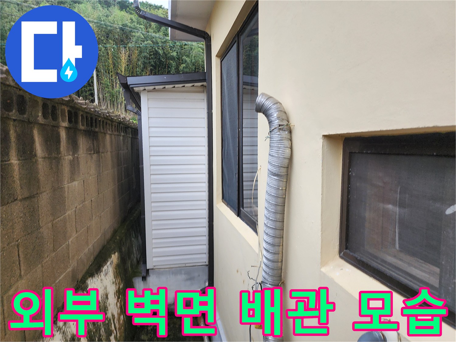건물 측면 외벽과 연결된 은색 주름관의 모습