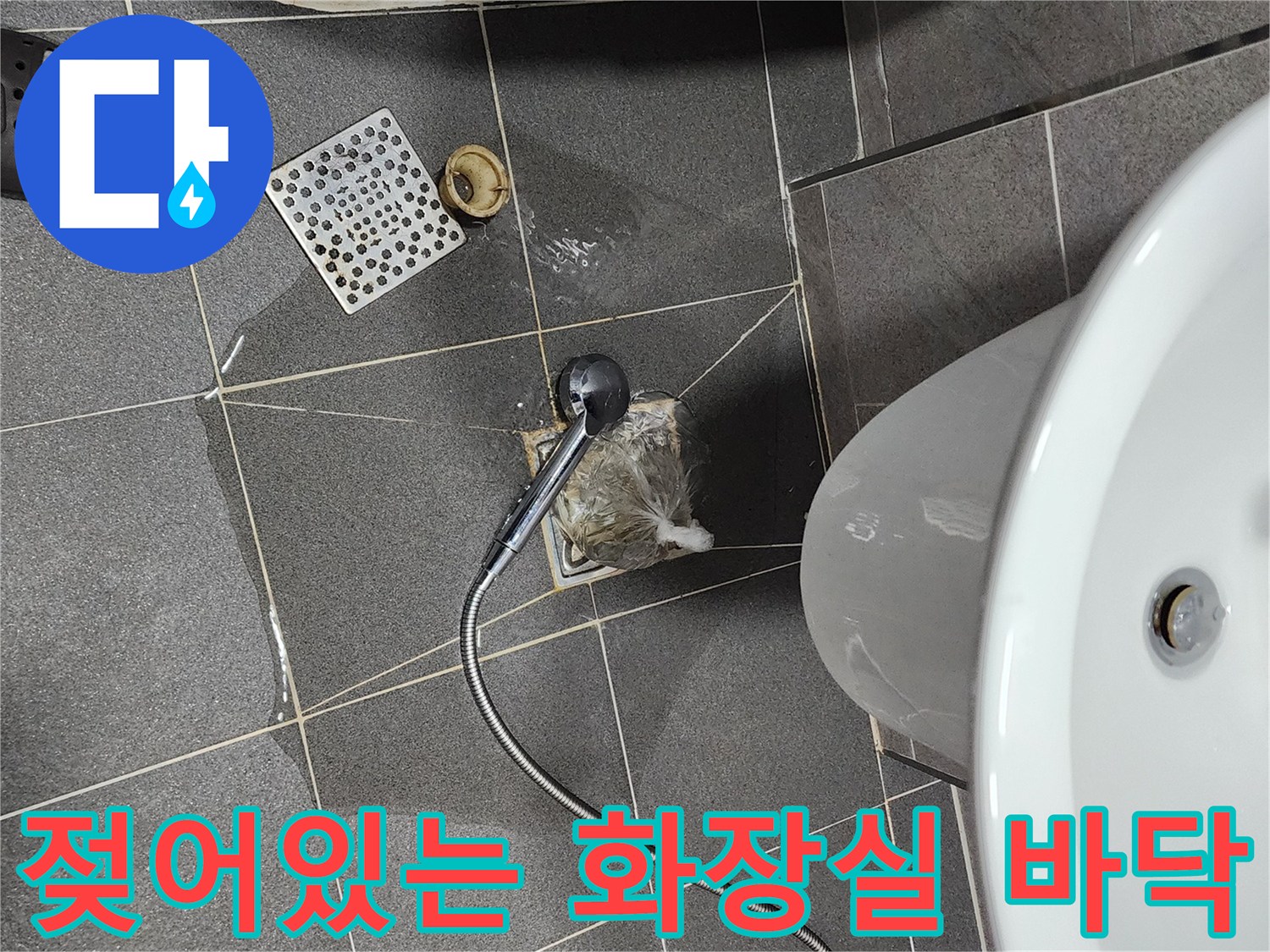 세면대 아래 배수구 주변 타일이 물에 젖어 있는 모습