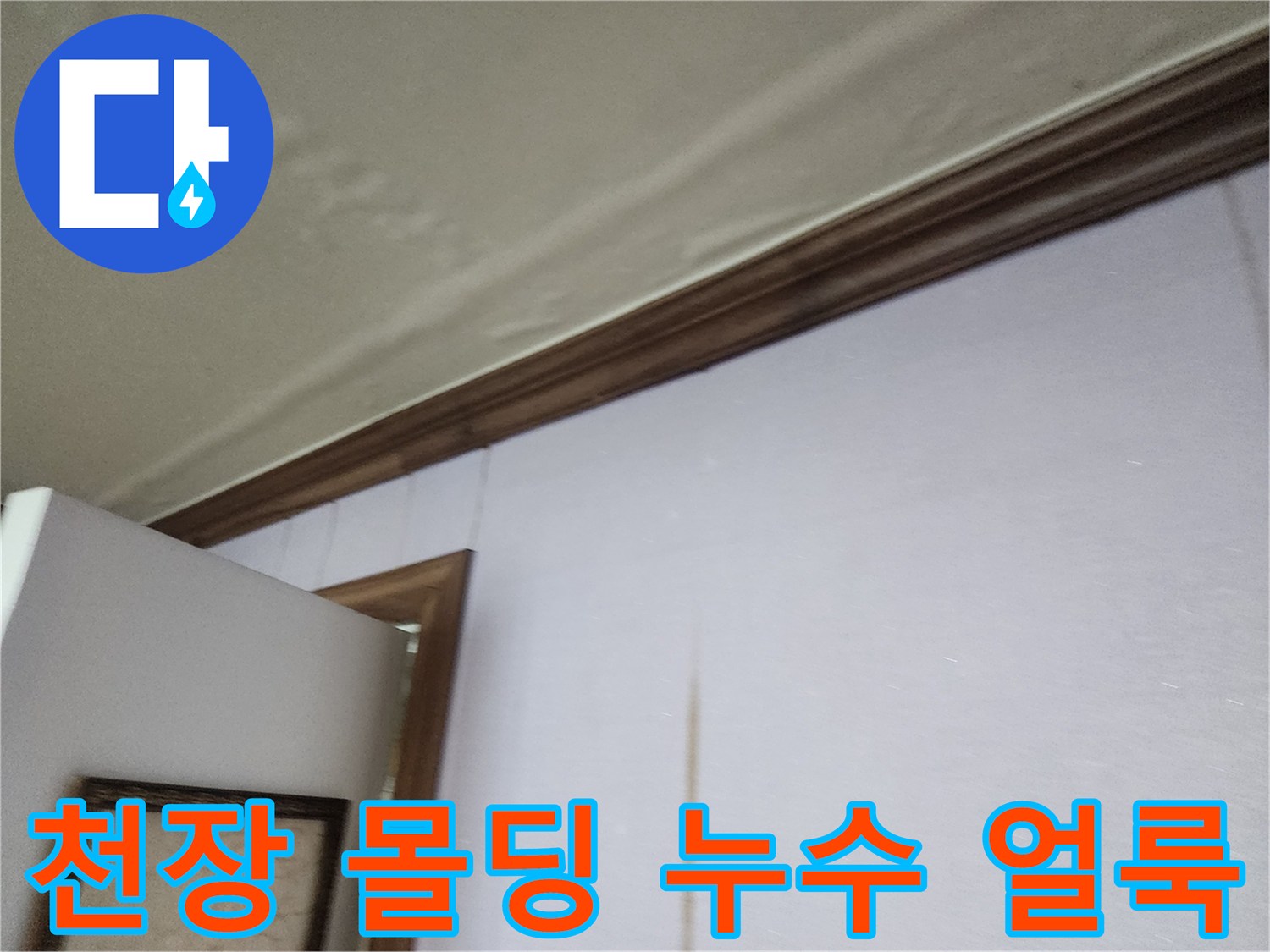 천장과 벽면 경계 부위의 젖은 얼룩 및 변색된 벽지
