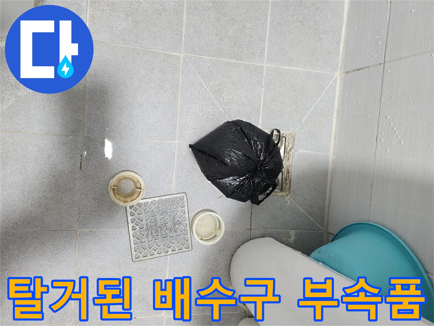 욕실 바닥에 놓인 배수 트랩과 주변 소모품 사진입니다.