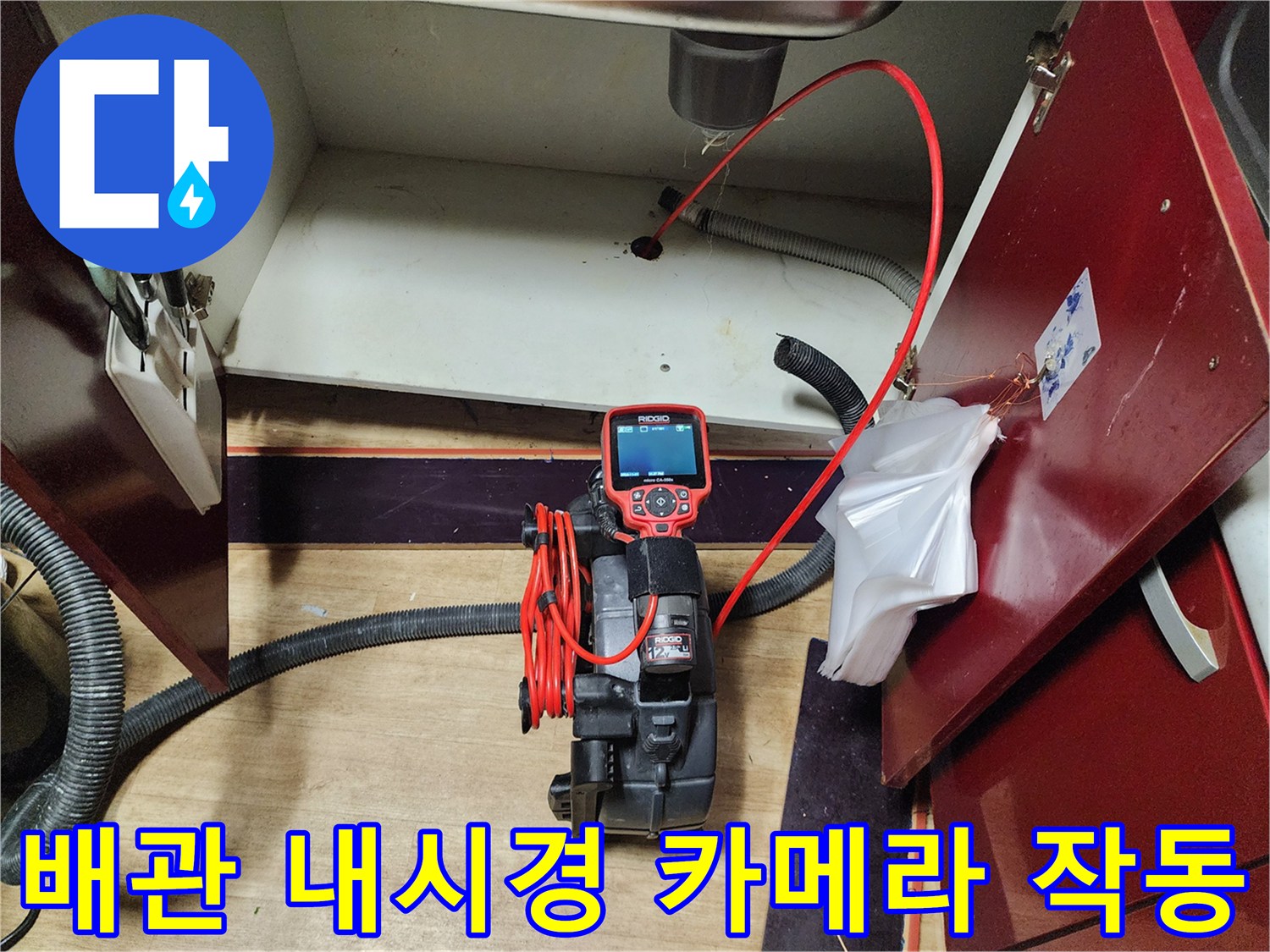 싱크대 하부 배관 구조와 내시경 장비가 배치된 모습