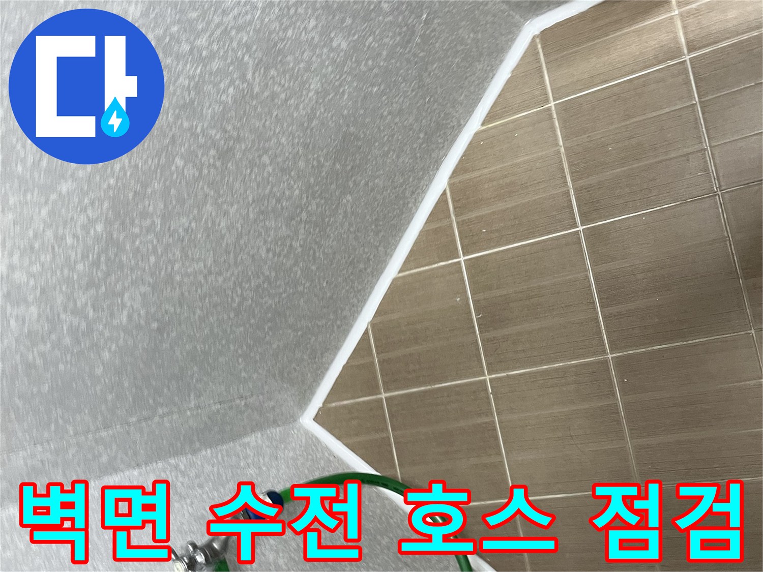 벽면에 설치된 수도꼭지와 초록색 급수 호스의 연결 상태