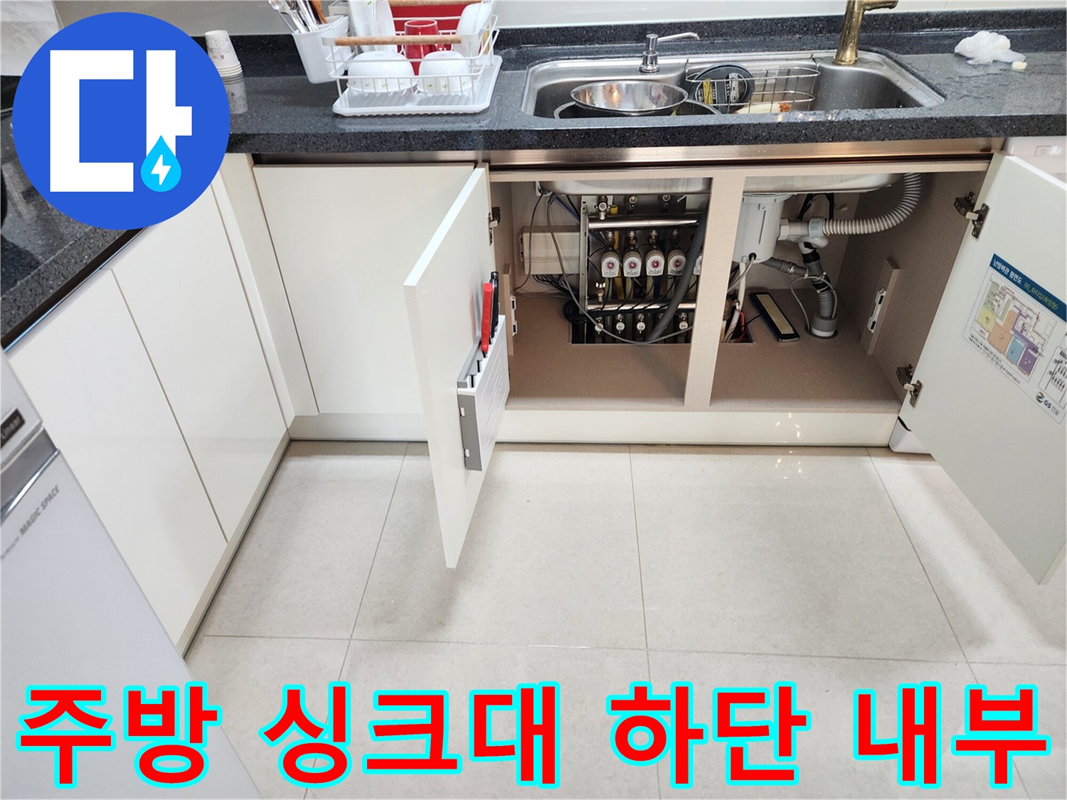 싱크대 아래쪽의 복잡한 배관 및 각종 연결 부품들