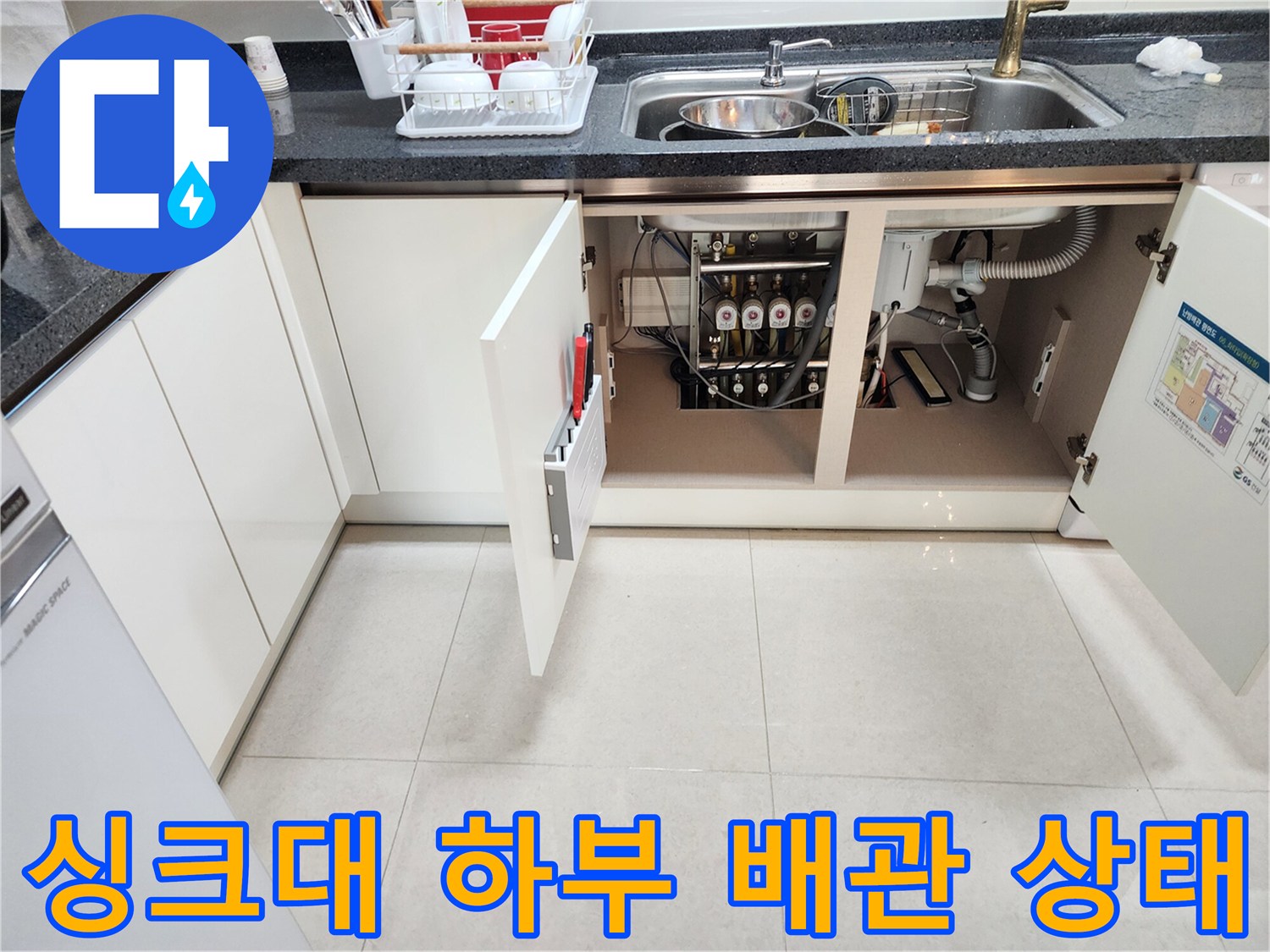 주방 싱크대-하부장 내부의 복잡한 배관 구조와 연결 부위 모습