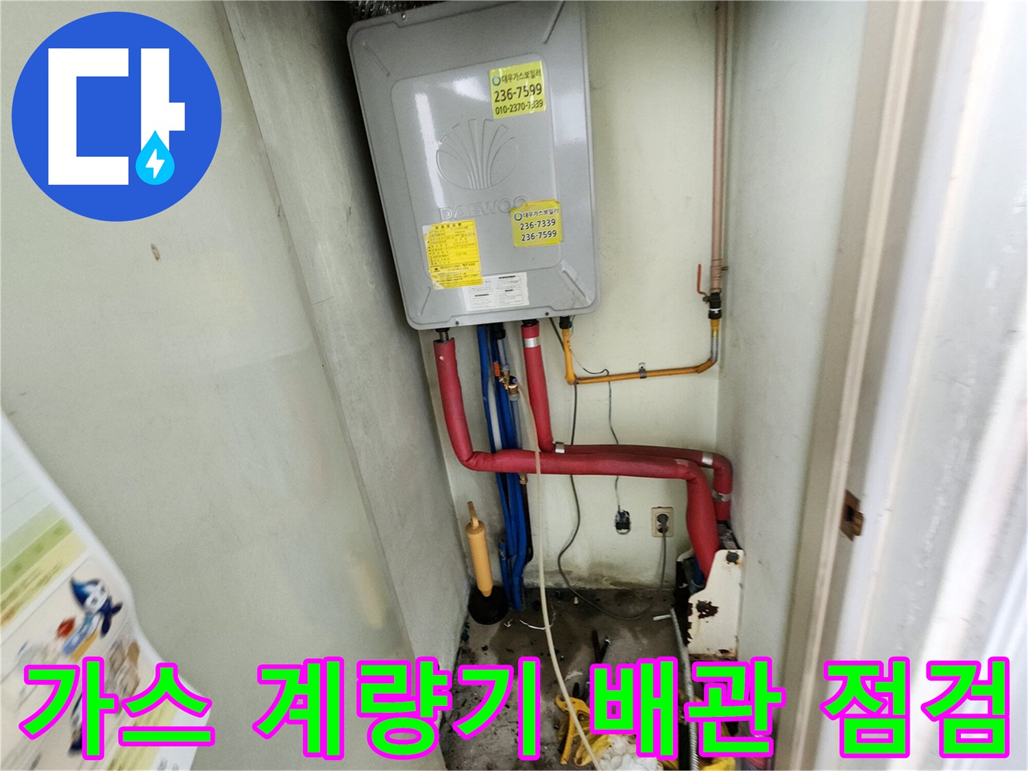 주방 하부의 가스 계량기와 붉은색 및 파란색 배관 구조물