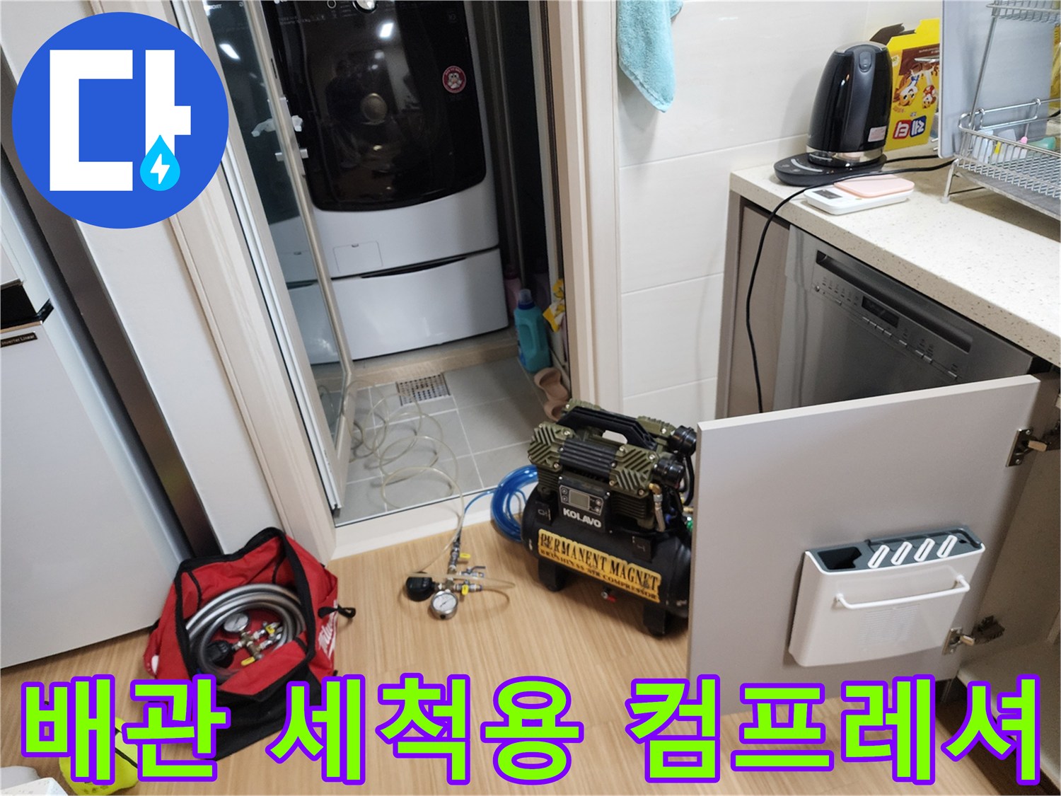 작업을 위해 싱크대 옆 바닥에 놓인 전문 배관 청소용 장비 세트