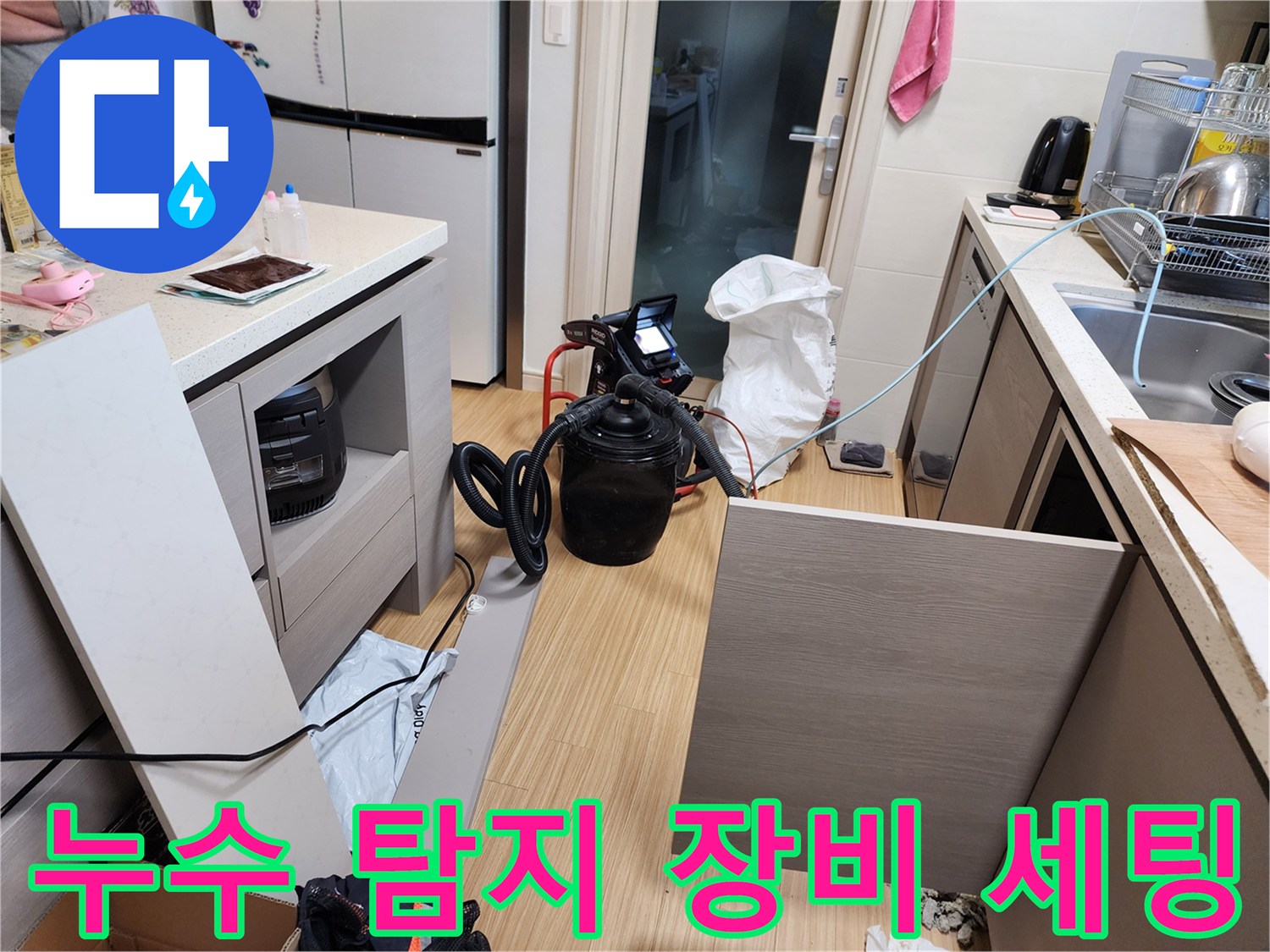 싱크대 하단 바닥 부근에 배치된 공압 테스트용 압력계와 호스 연결 상태