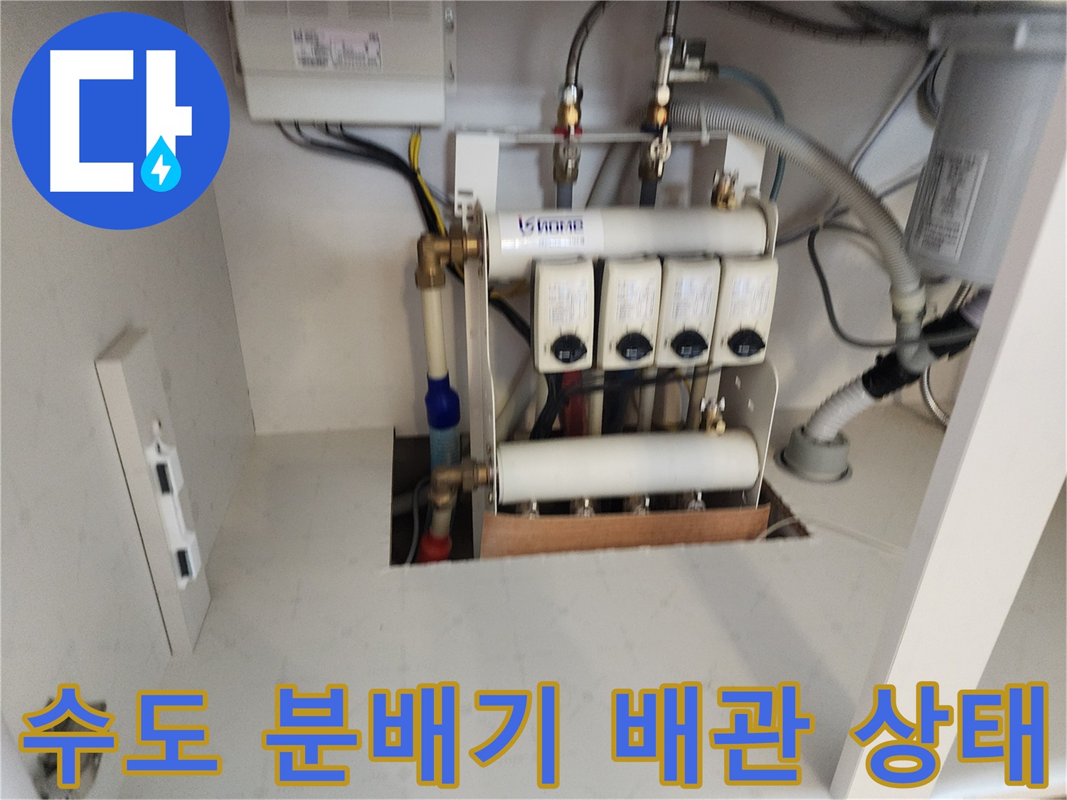 싱크대 하부장 내부에 노출된 수도 분배기와 연결 배관