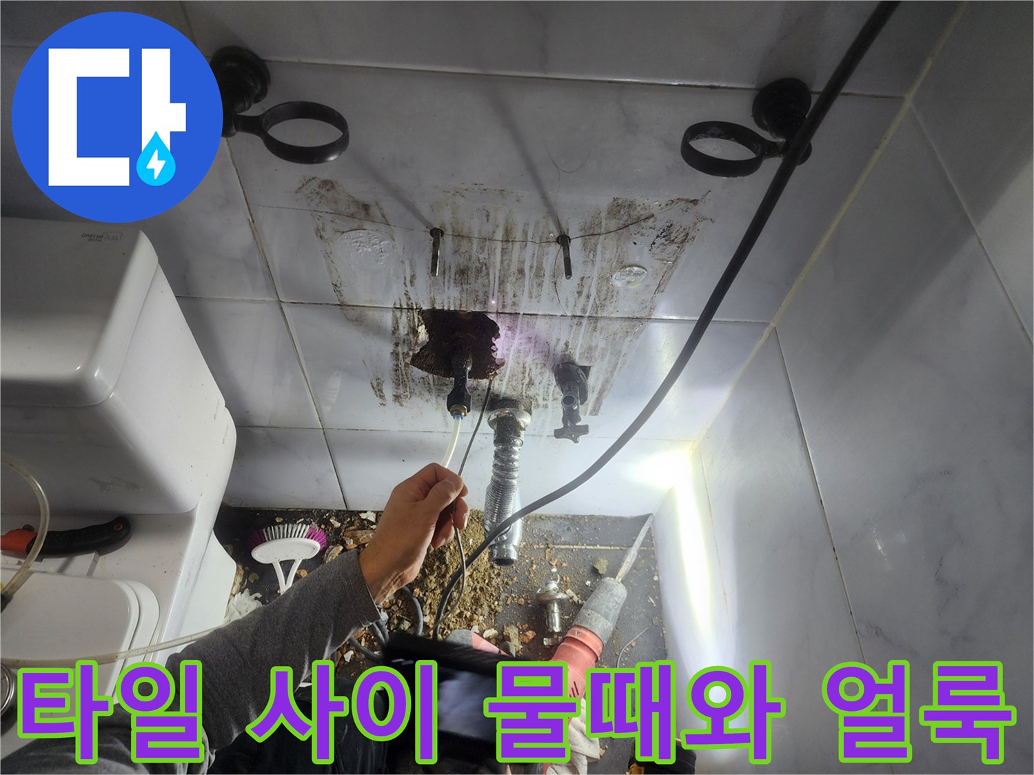 배관 주변 타일의 갈색 얼룩과 습기 노출 상태
