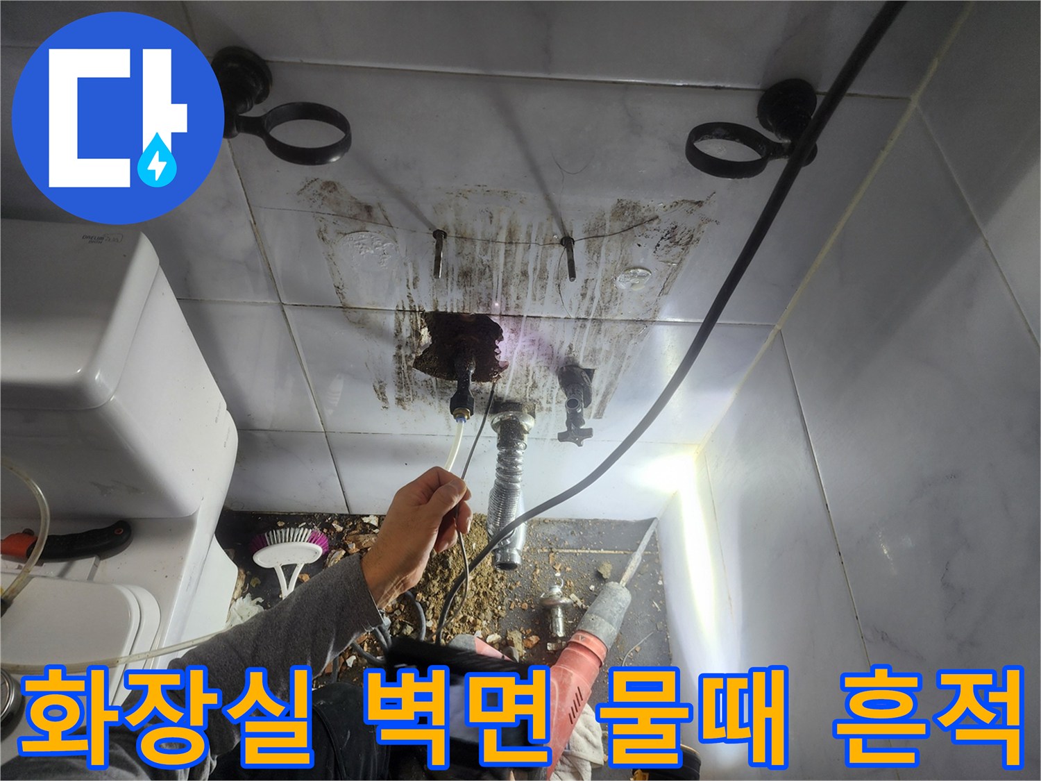 배관 주변의 짙은 얼룩과 습기가 침투한 화장실 타일