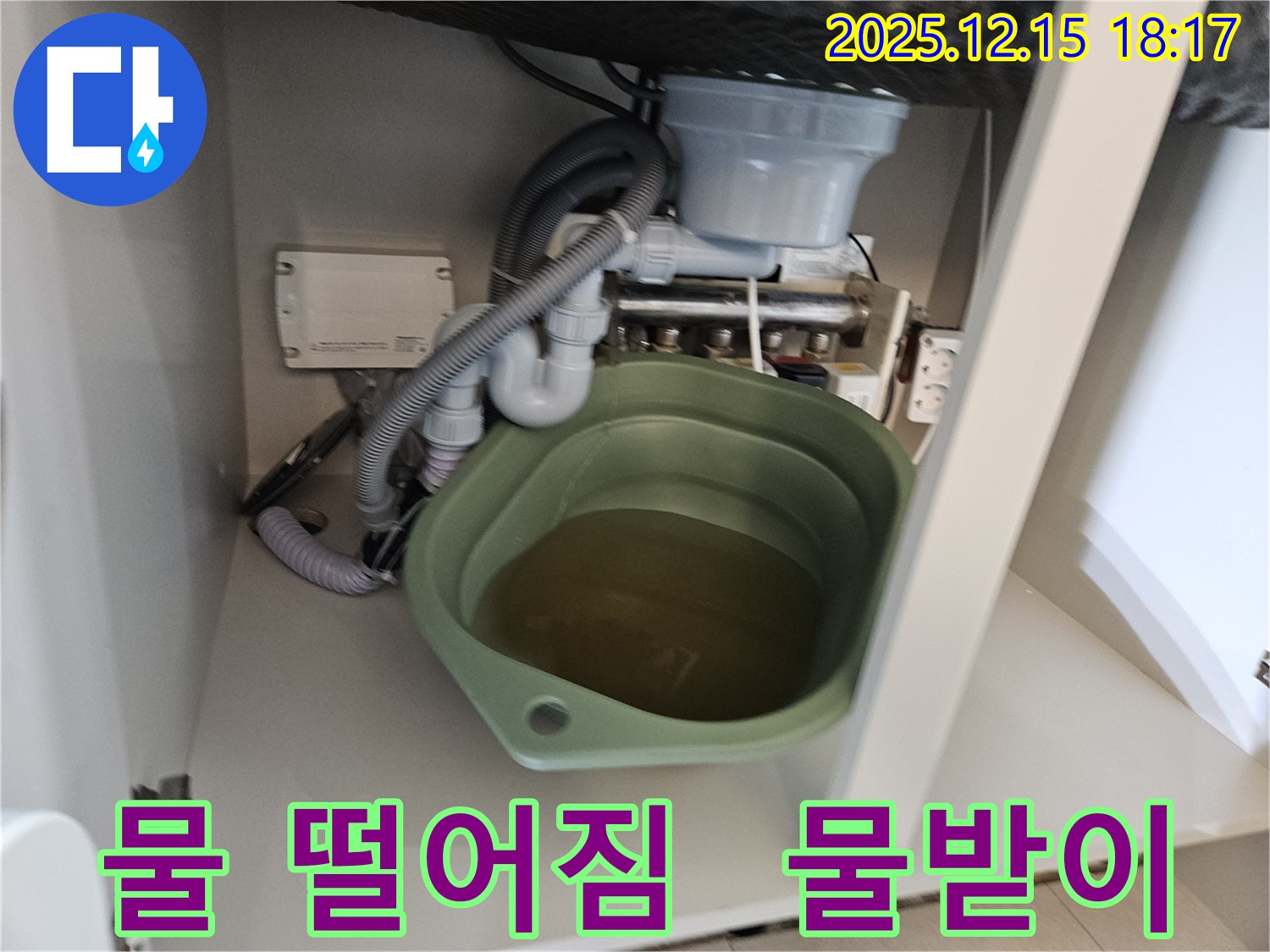 싱크대 밑에서 물이 떨어지는 모습 - 누수의 초기 증상일 수 있습니다. 물받이를 확인하고 전문가에게 즉시 문의하세요.