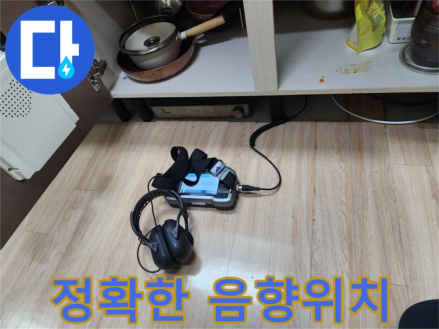 누수 지점의 정확한 위치를 파악하기 위해-음향 탐지 장비와-헤드폰을 함께 사용하여-면밀히 검사하고 있습니다.