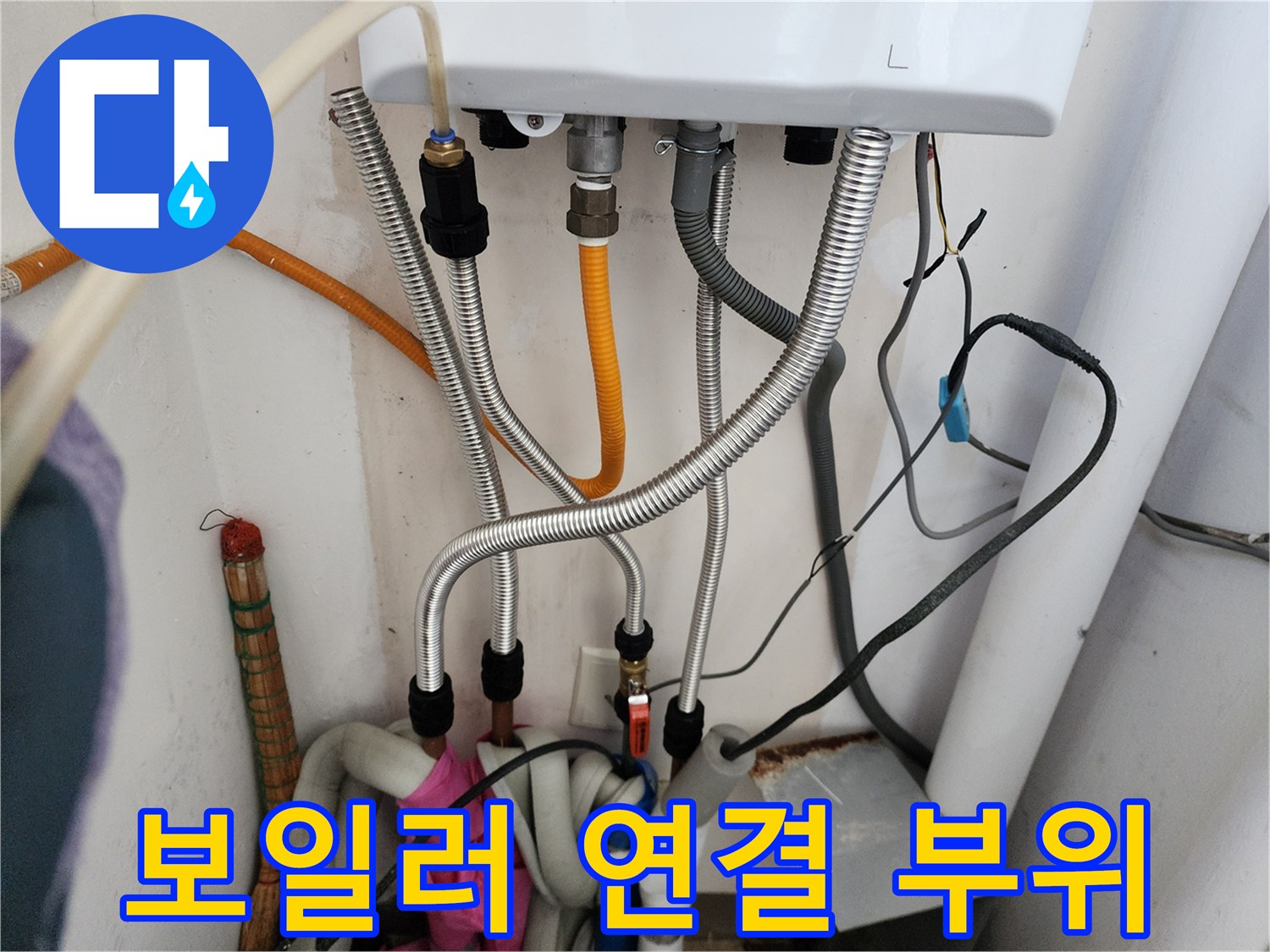 보일러-하단에-연결된-금속-주름관과-호스들
