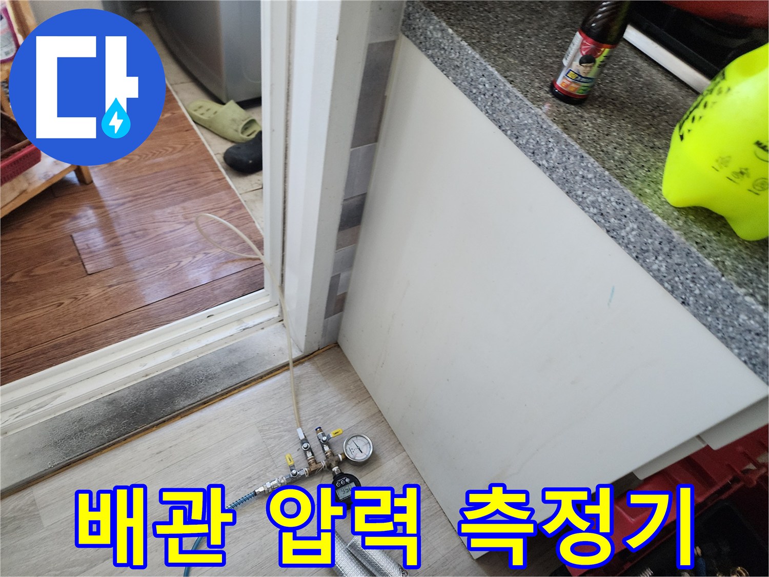 파란색 호스와 압력 게이지가 연결된 배관 부속 장비