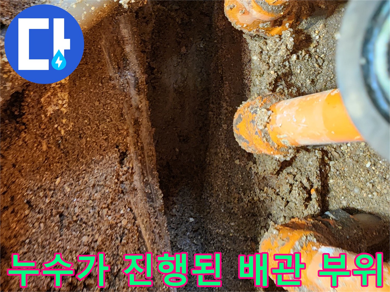 축축하게-젖은 흙과 오렌지색 배관 연결부 모습