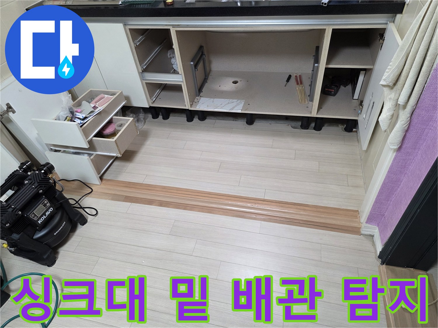 가스 탐지 장비와 함께 싱크대 하부 공간을 점검하는 엔지니어의 작업 모습입니다.