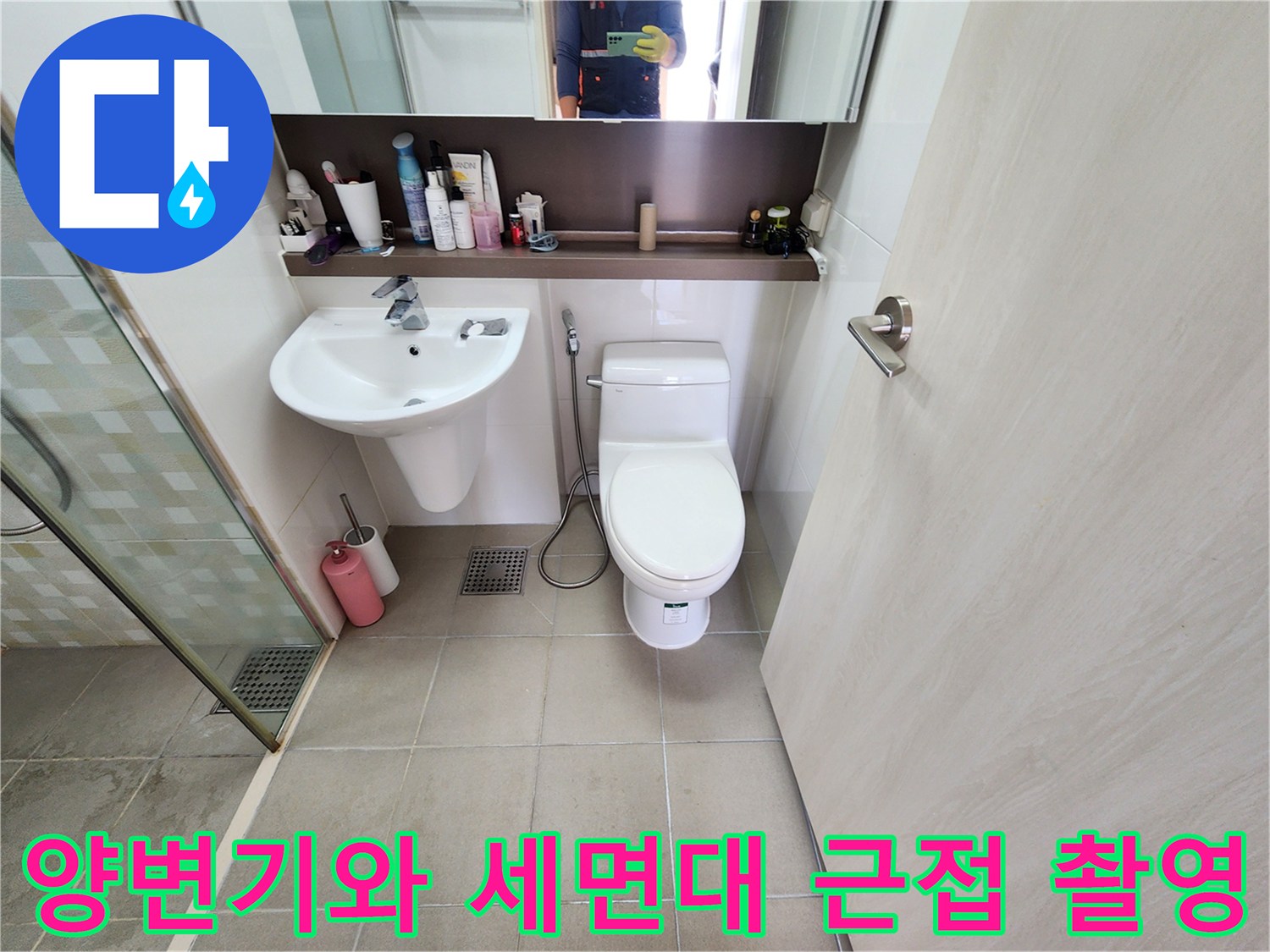 양변기와 세면대가 설치된 화장실 내부의 배관 및 타일 상태 사진입니다.