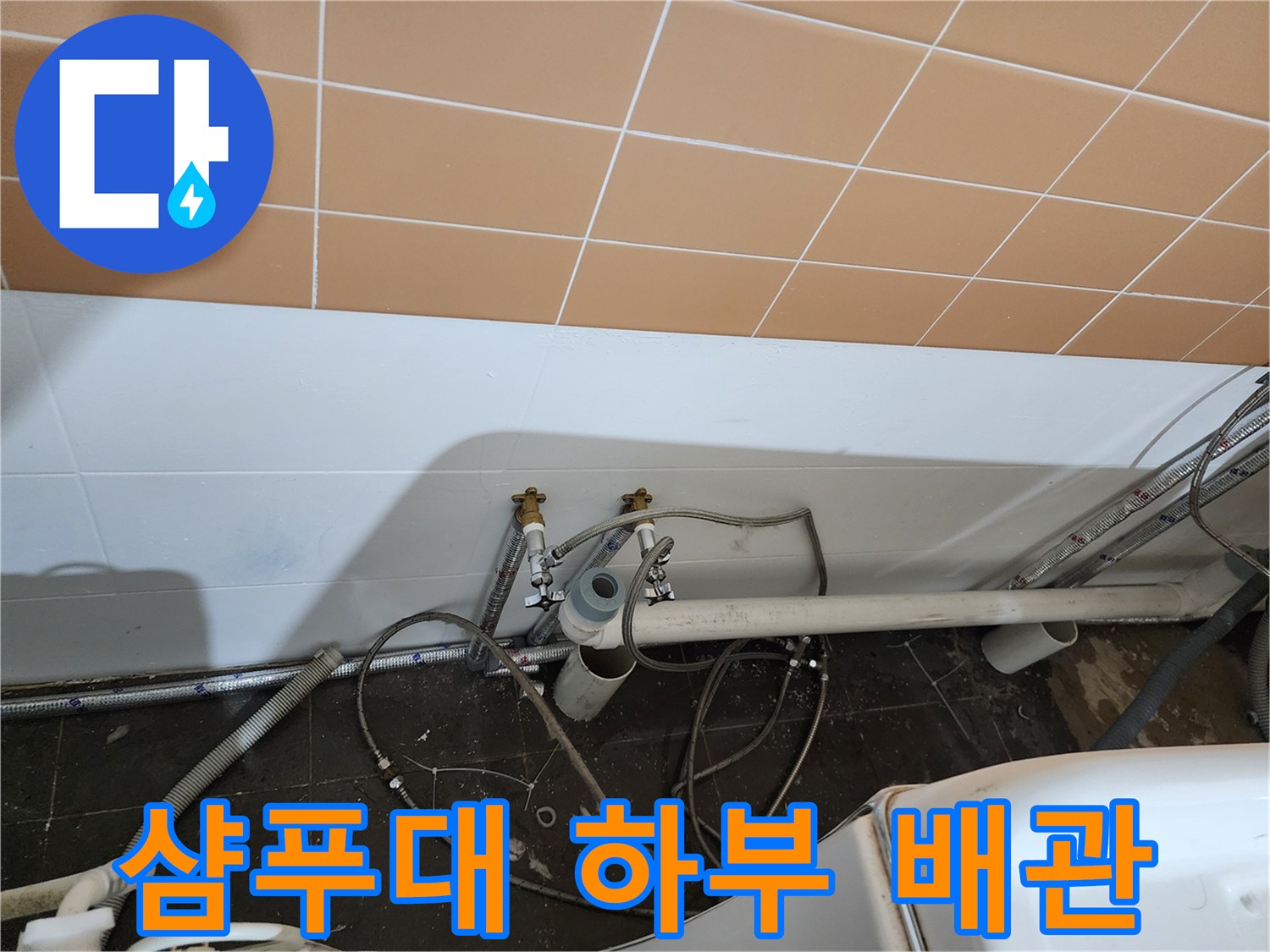 미용실 샴푸대 아래쪽의 노출된 배관과 연결 부위 상태를 보여주는 사진입니다.