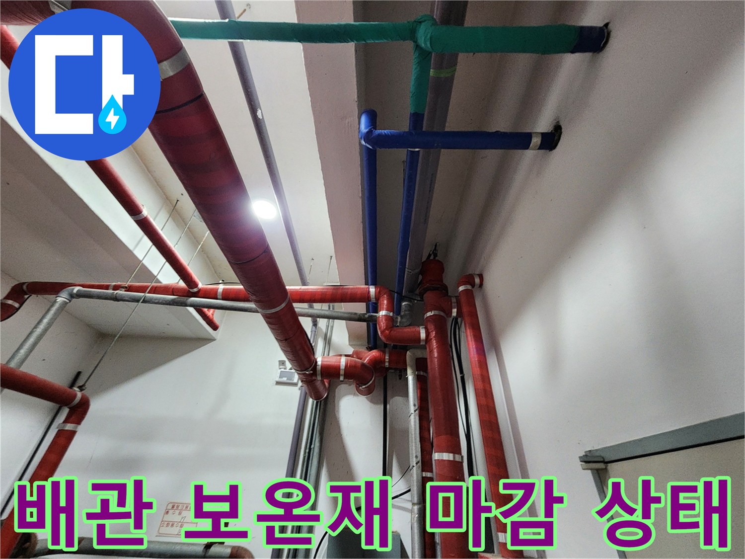 붉은색과 푸른색 배관의 보온재 마감 및 고정 부위 근접 촬영