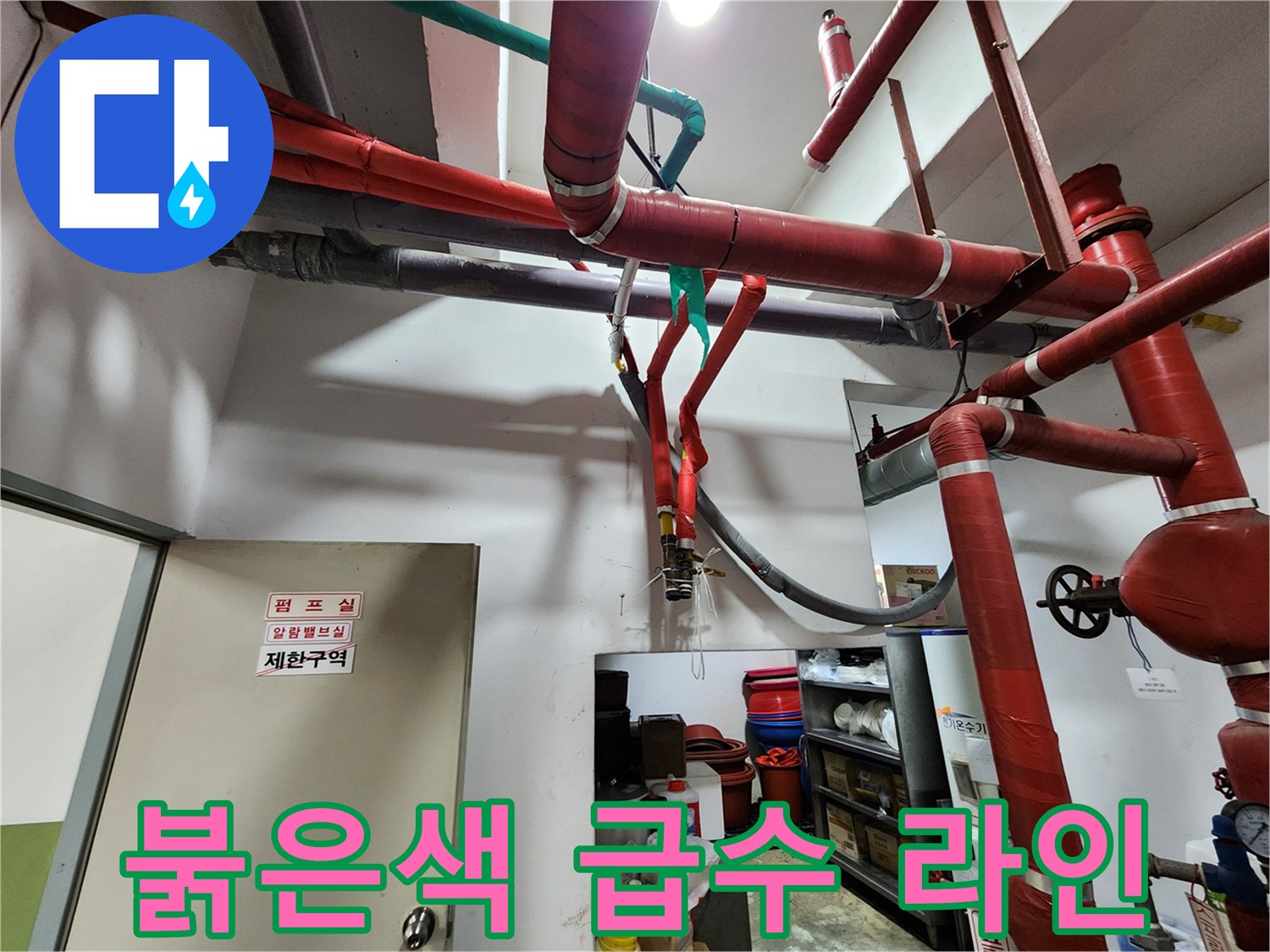 천장에 가로지르는 붉은색 배관과 지지 구조물입니다.