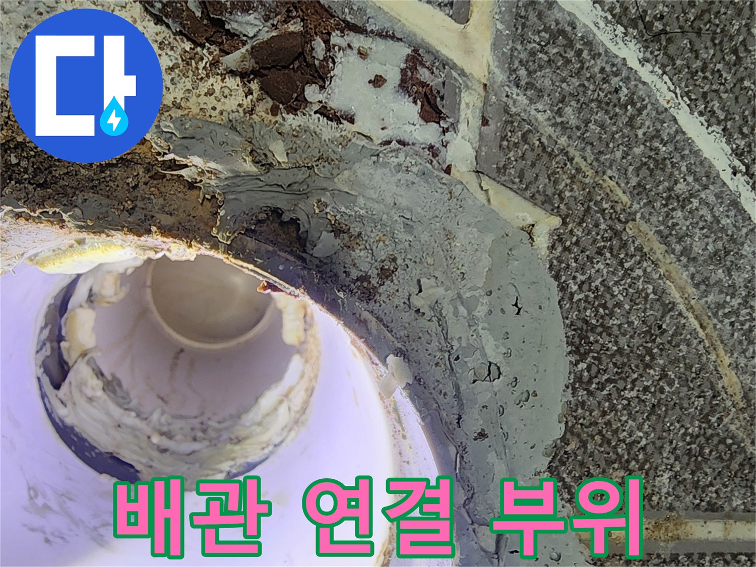 노후된 배관 연결부와 젖은 마감재를 근접 촬영한 이미지입니다.
