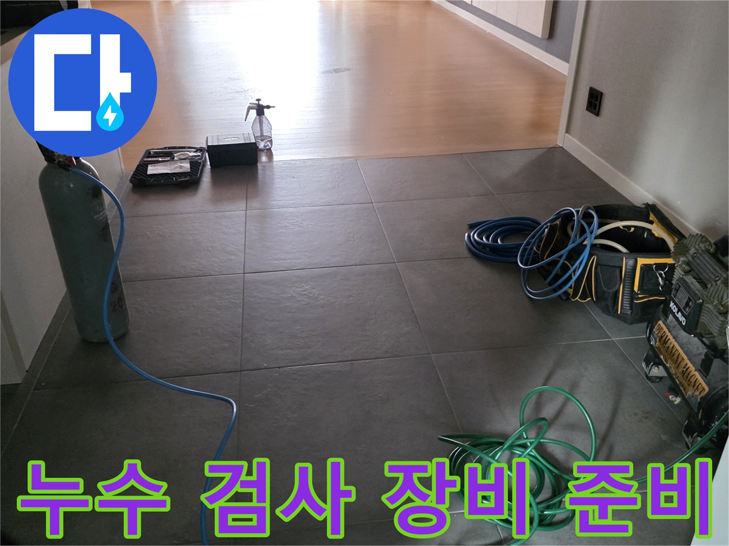 거실 타일 위에 놓인 가스 탐지용 실린<0xAE>더와 호스 뭉치