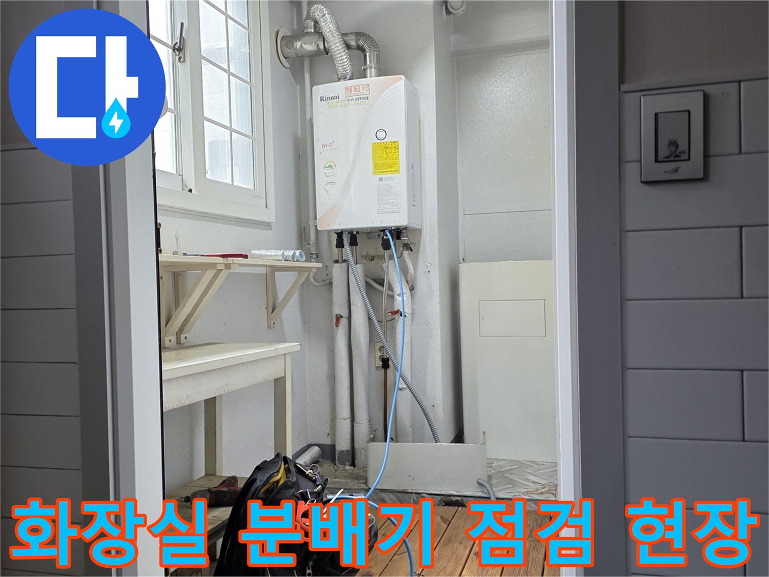욕실 벽면에 설치된 온수 제어 장치와 하단 배관 라인
