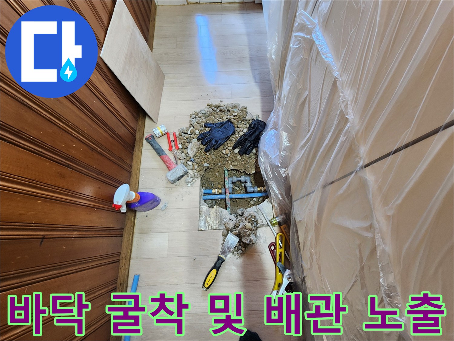 작업을 위해 바닥을 파낸 뒤 드러난 푸른색 배관과 주변 작업 도구