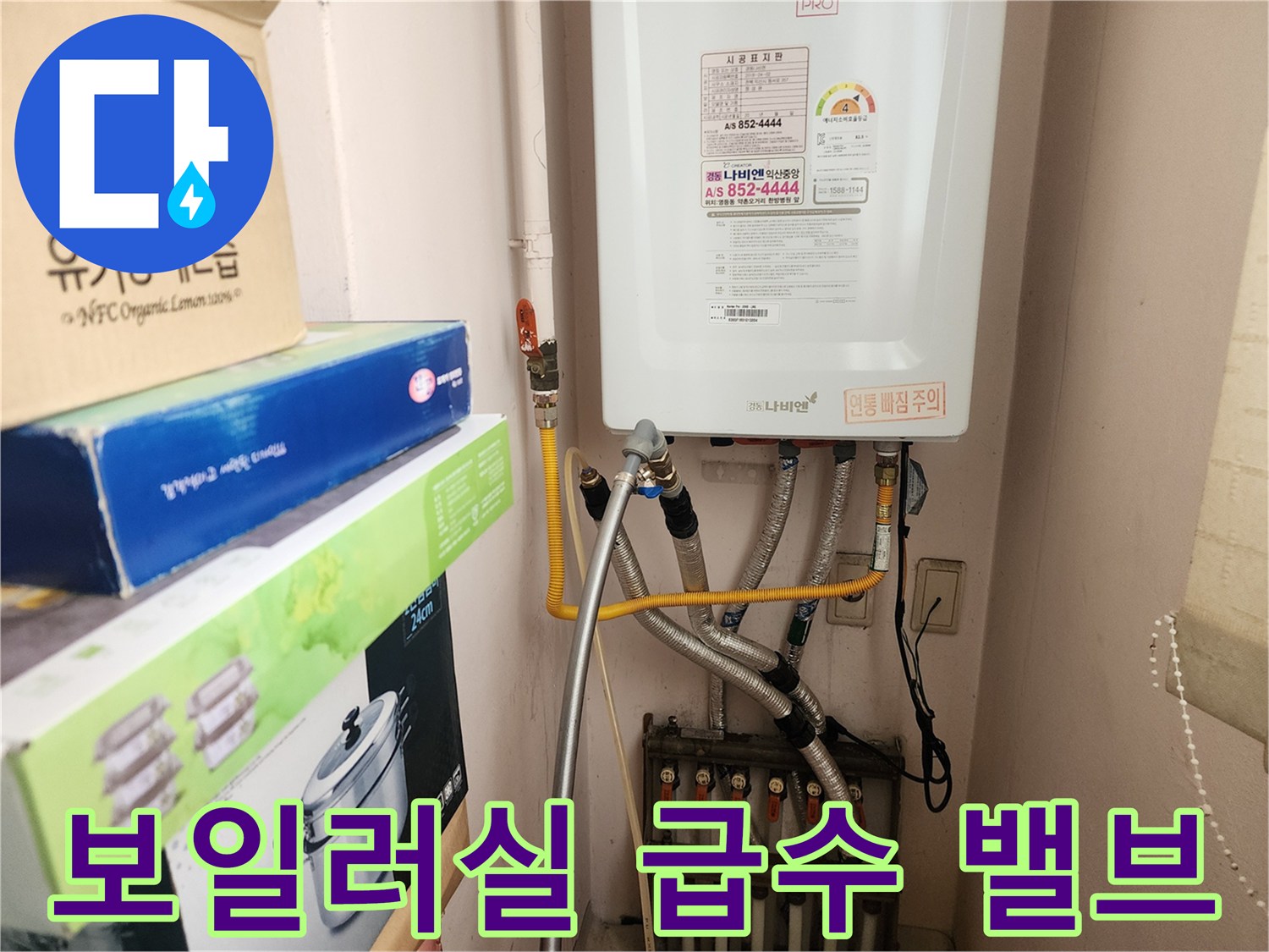 보일러 아래에 설치된 황동색 급수 밸브와 배관들