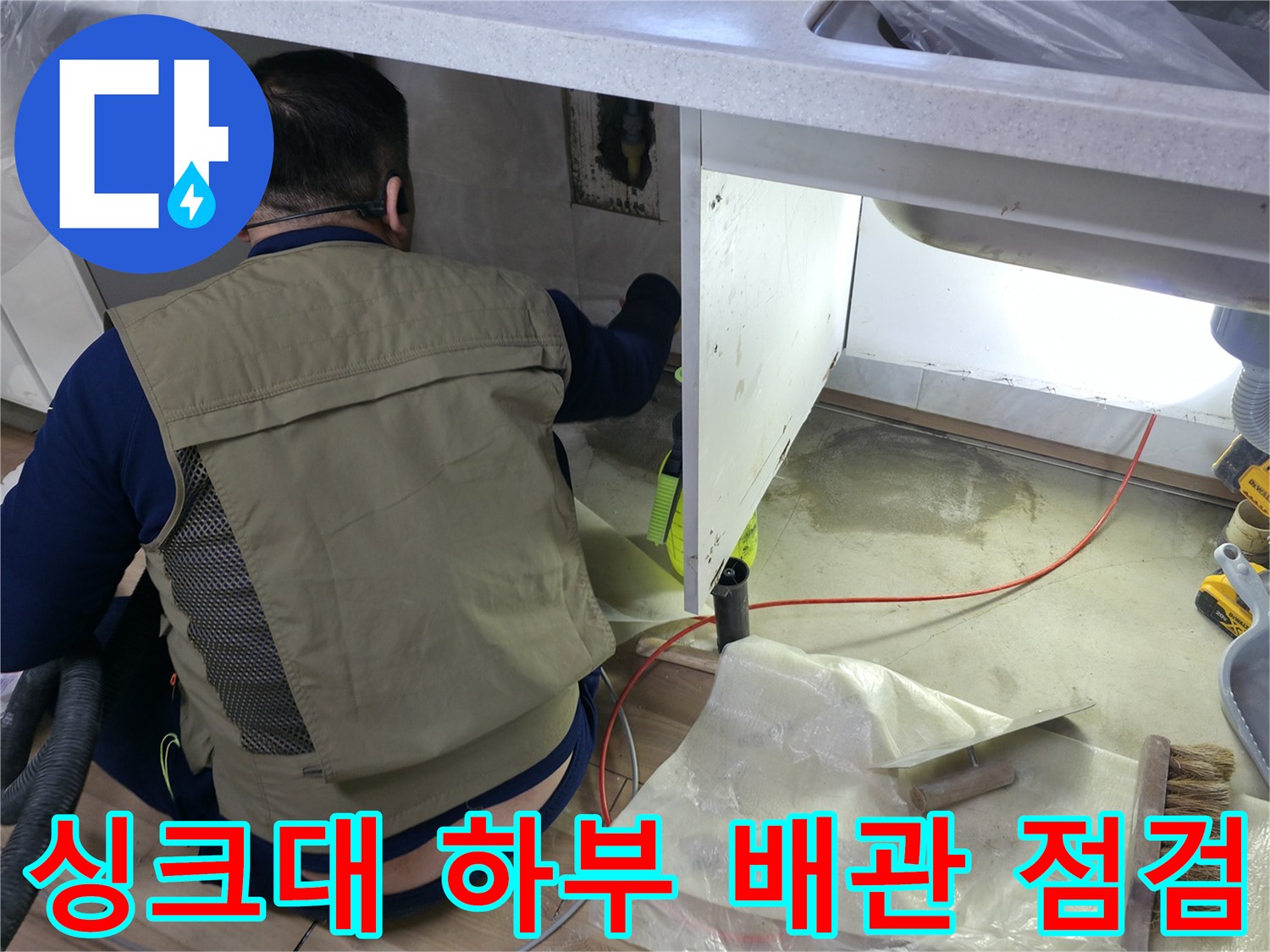 싱크대 밑 공간에서 작업 중인 수도 배관 상태