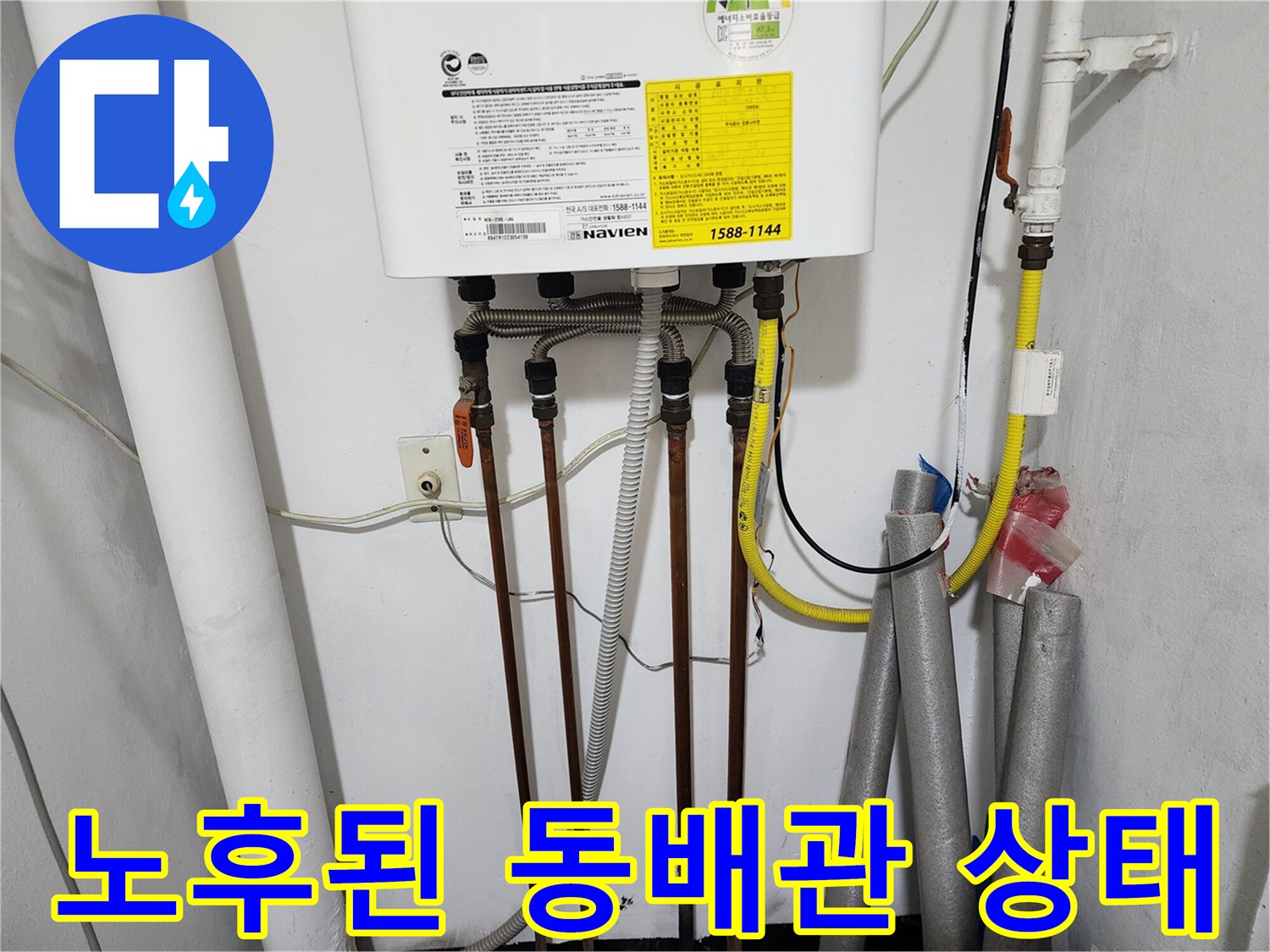 보일러 하단부의 복잡한 배관 연결 구조와 노란색 가스 호스