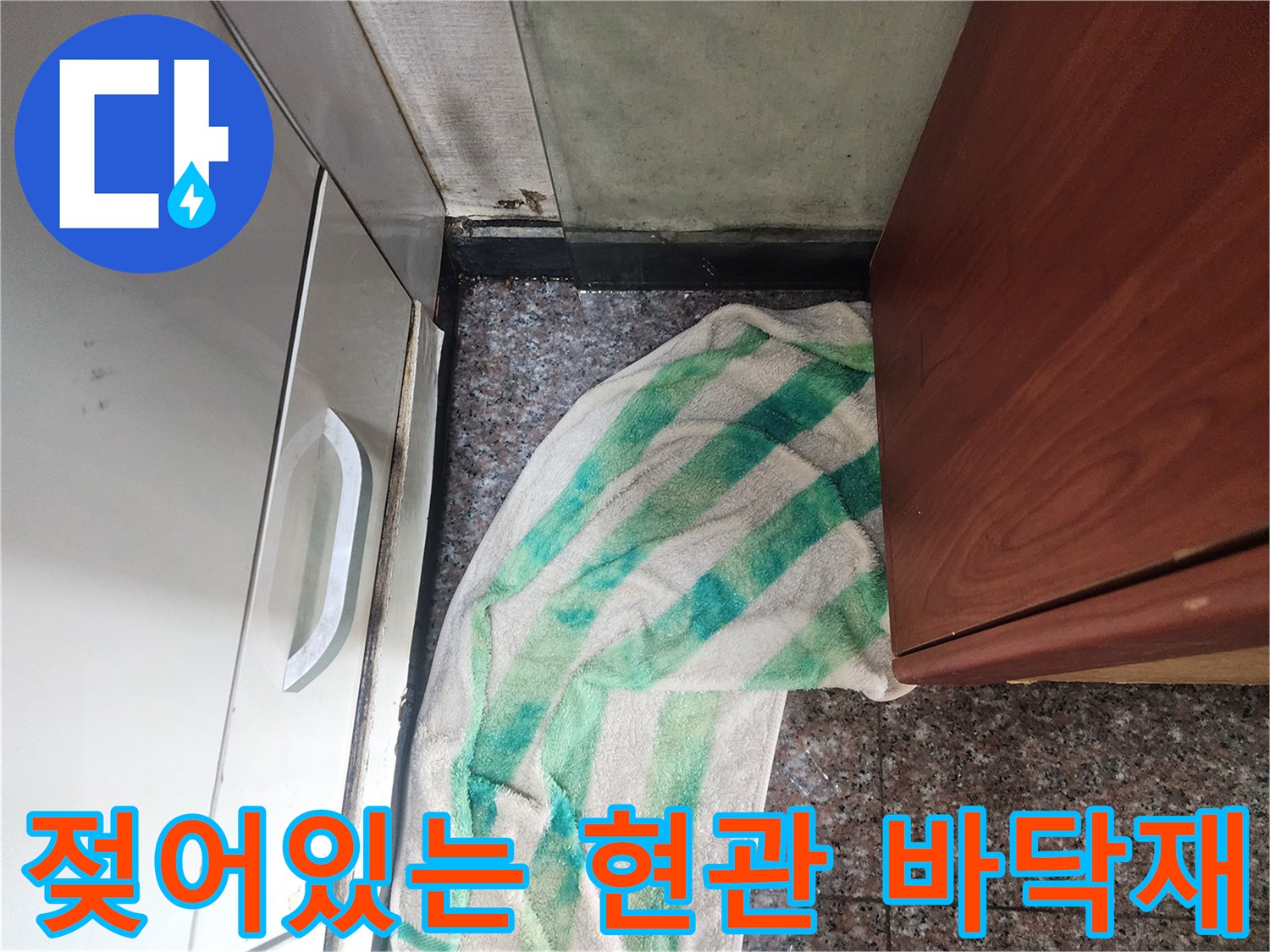 물기가 스며든 현관 타일과 젖은 수건의 모습