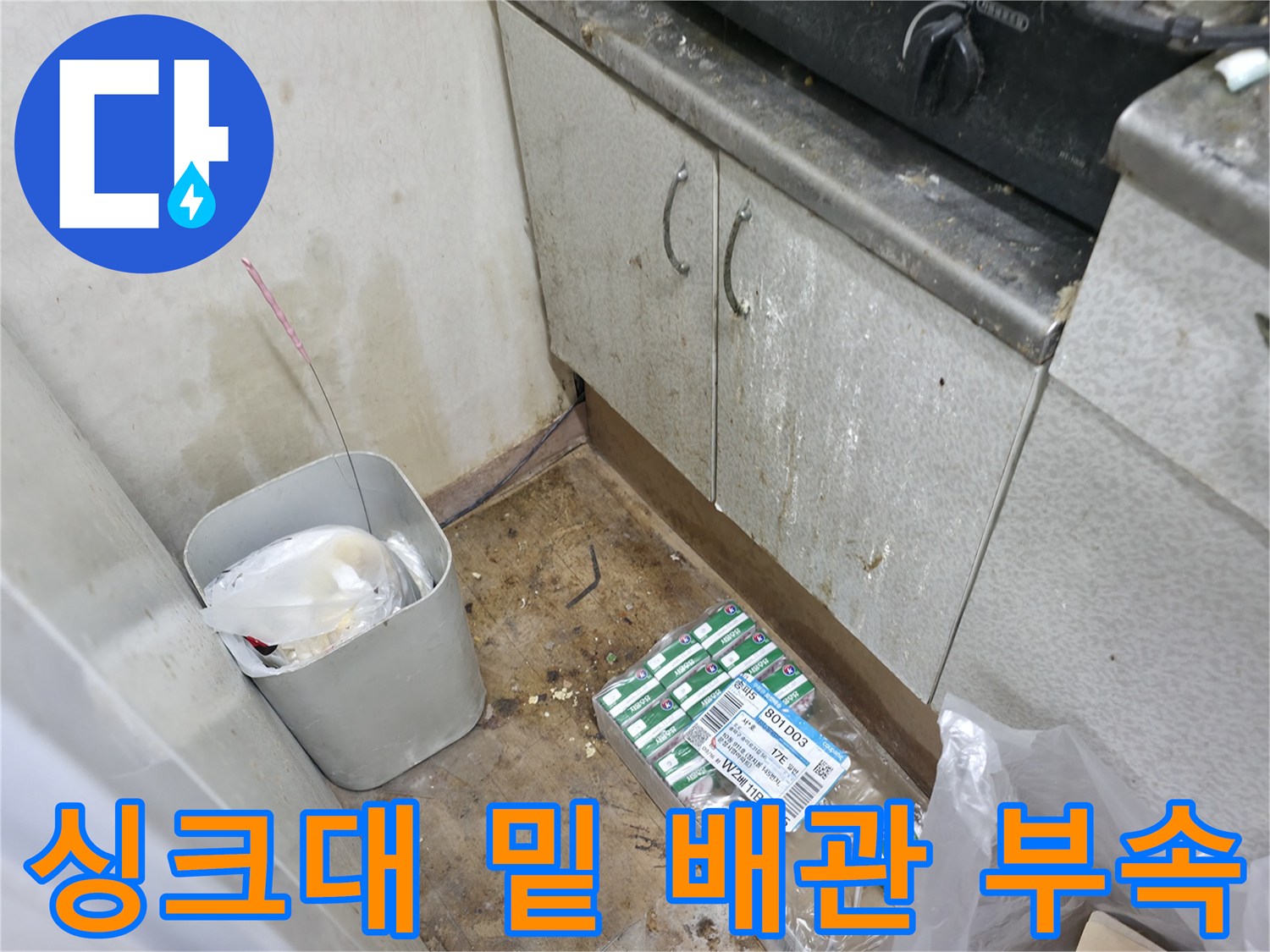 싱크대 아래 놓여있는 배관 연결용 부품과 공구들