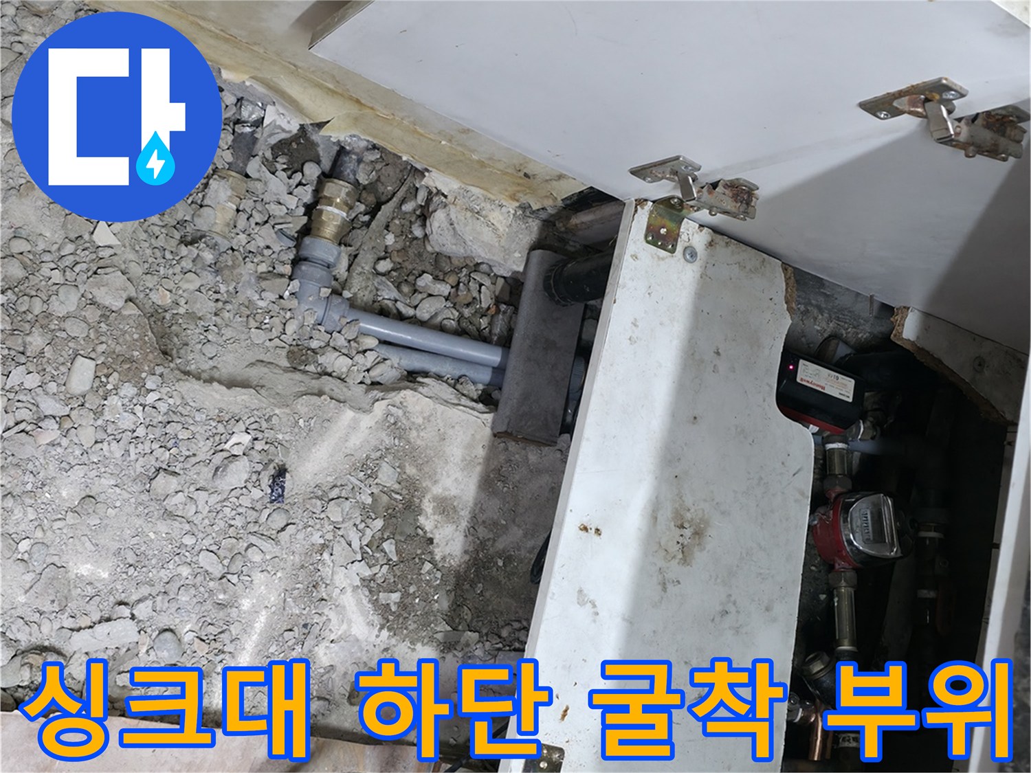 주방 싱크대 밑-노출된 배관과 파쇄된 콘크리트 잔해