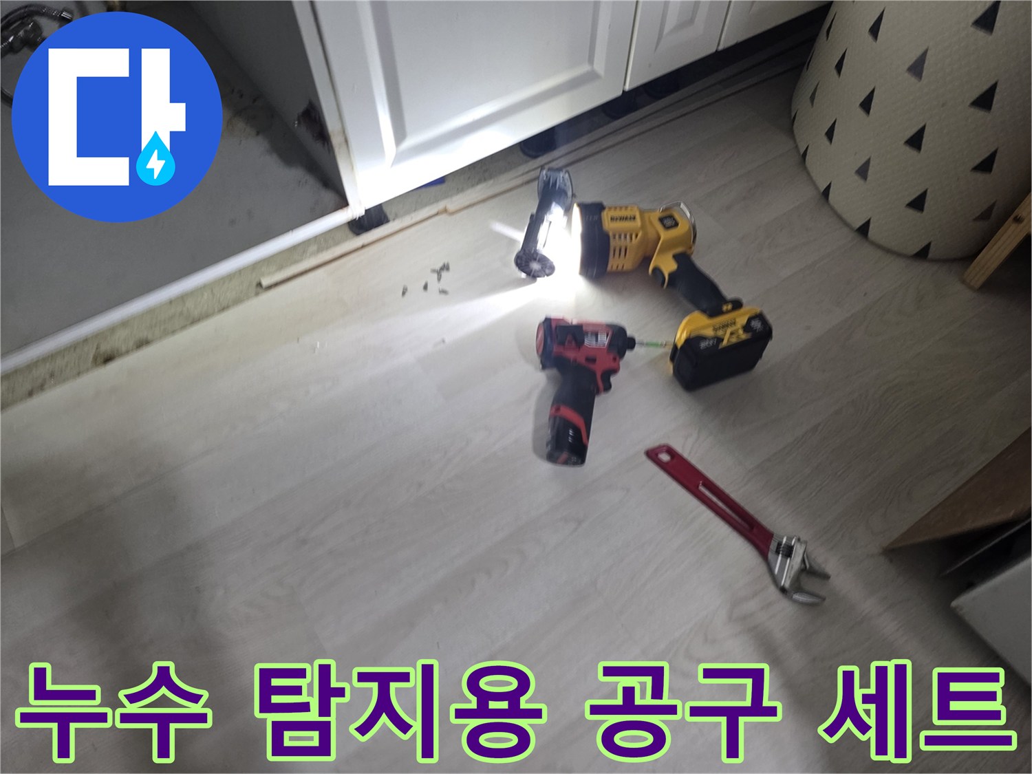 싱크대 밑 배관 상태를 확인하기 위한 렌치와 드릴의 모습