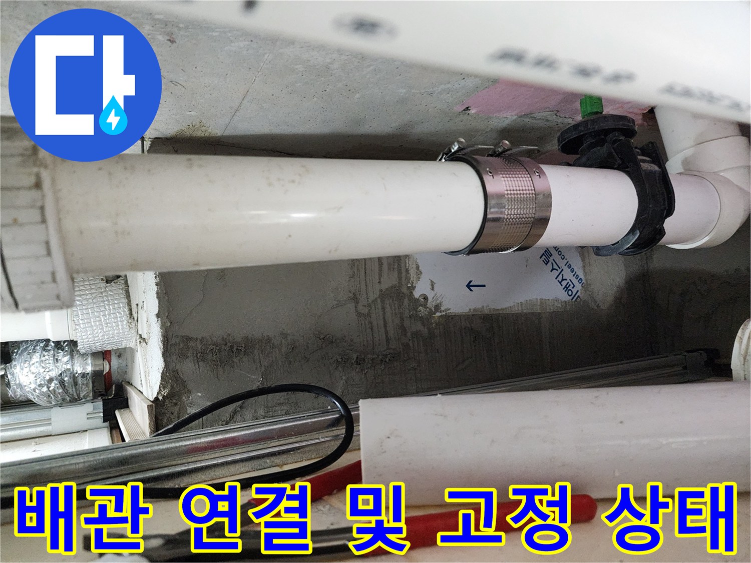 하얀색 PVC 배관과 금속 밴드로 고정된 천장 내부 모습