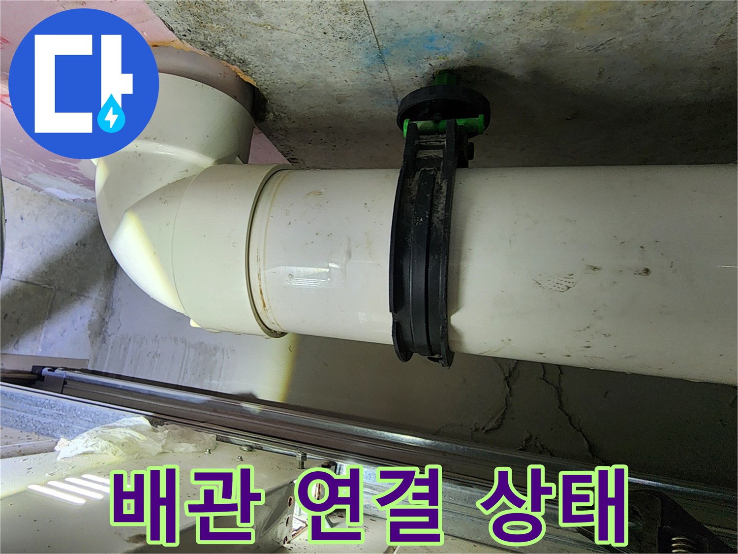 하얀색 PVC 엘보 부속과 검은색 배관 고정 장치 근접 촬영
