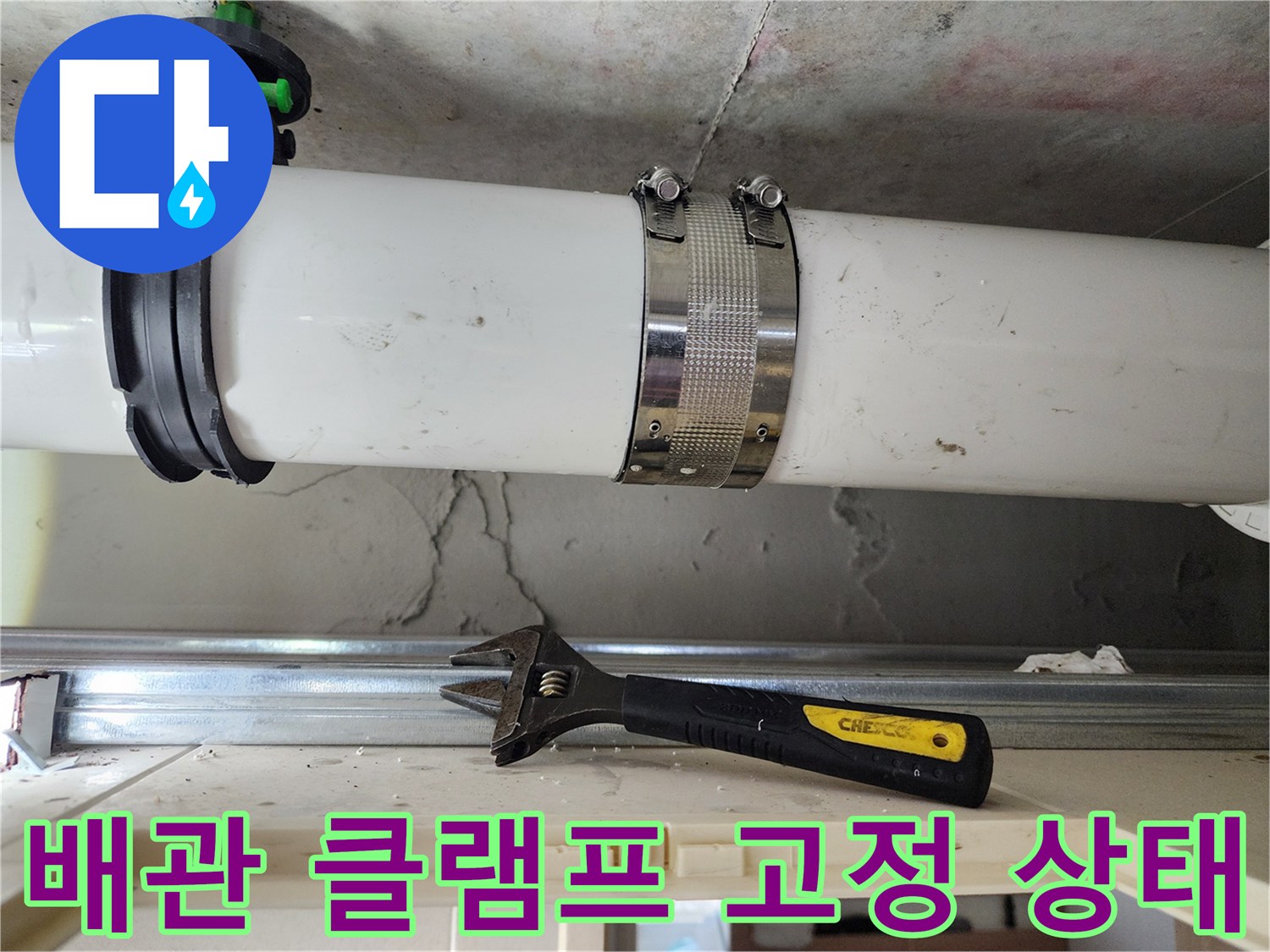 화장실 천장 내부-배관을 단단하게 고정하고 있는 호스 클램프와 렌치