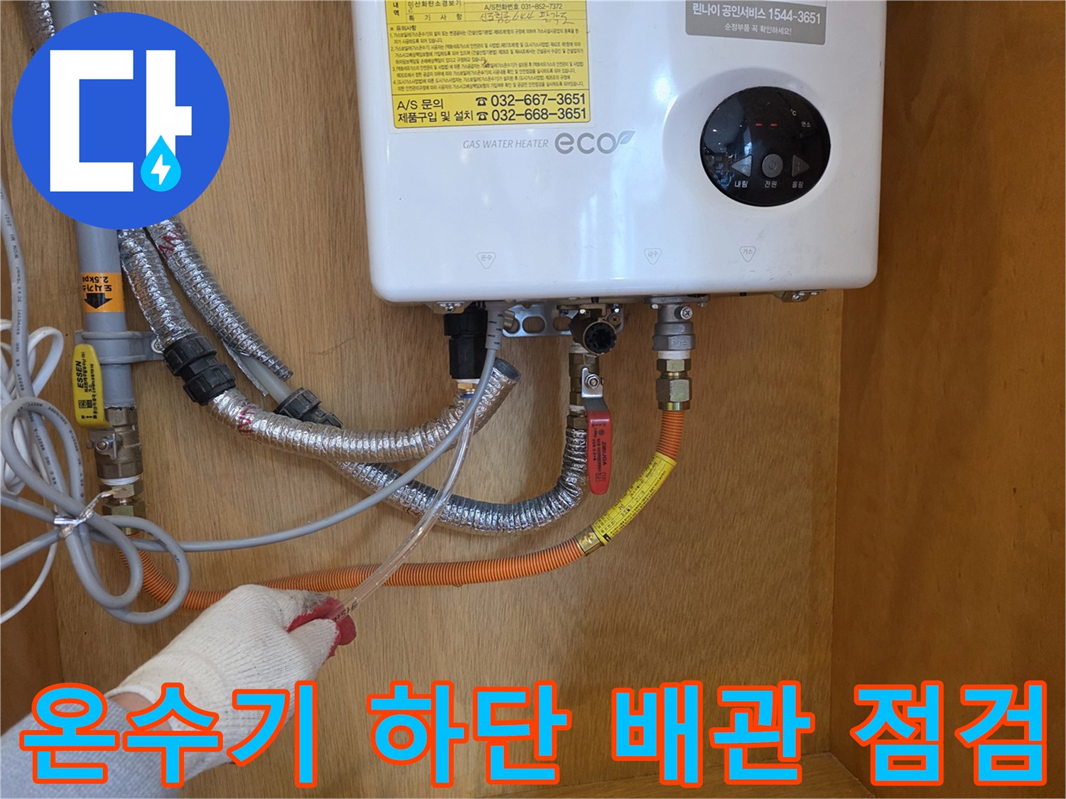 가스 온수기 아래쪽의 배관 연결 부위와 밸브 상태를 확인하는 모습