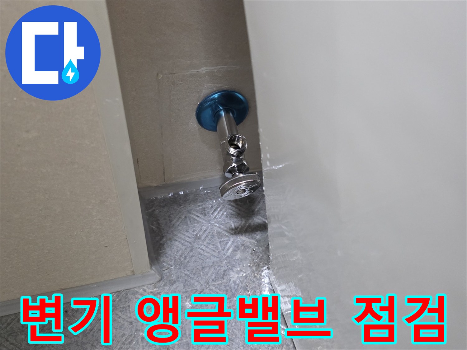 화장실 벽면 판넬 사이로 노출된 앵글밸브와 배관 연결 부위