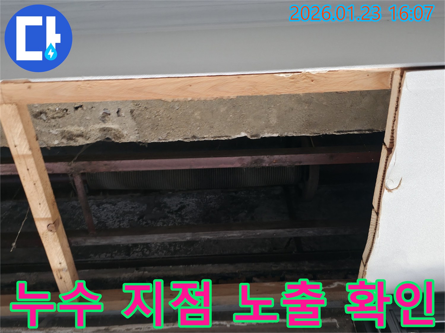 배관 누수 점검 중-콘크리트와 목재-금속 구조물이 드러난 상태