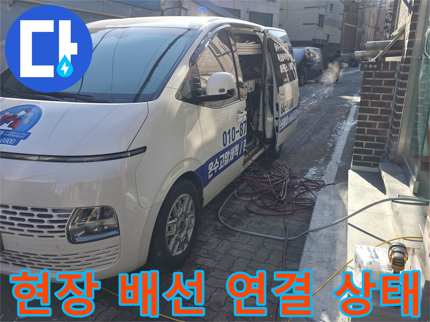 작업 차량 측면과 바닥에 놓인 긴 전기 연장선