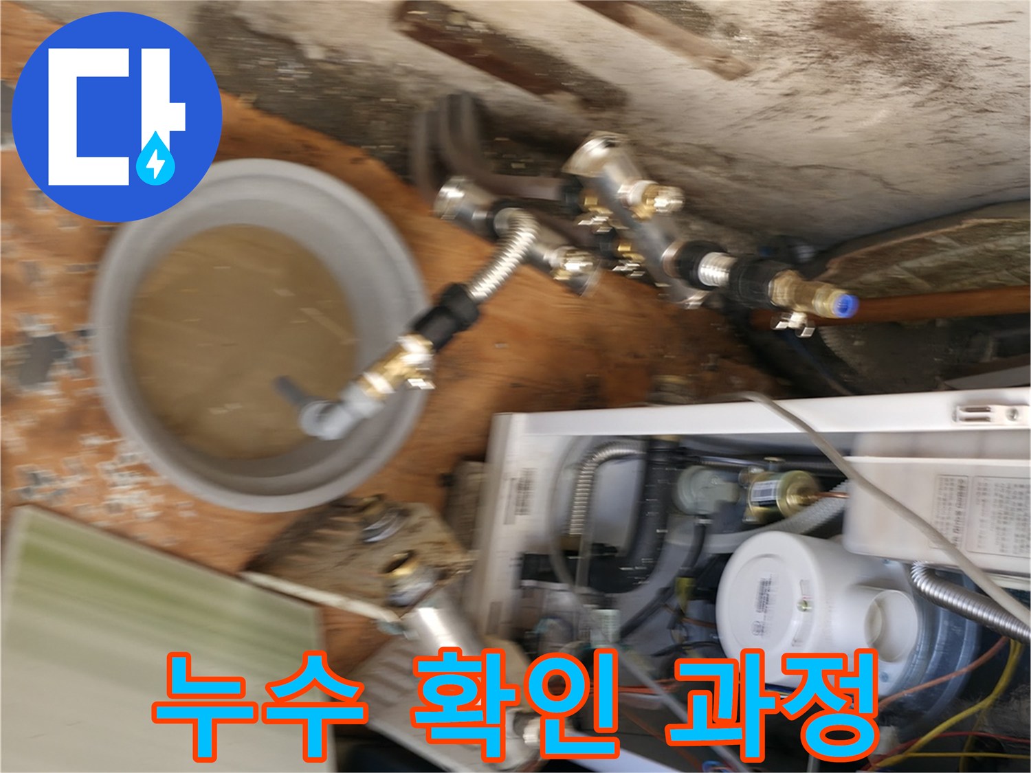 보일러 밑 배관과 물이 담긴 통의 모습