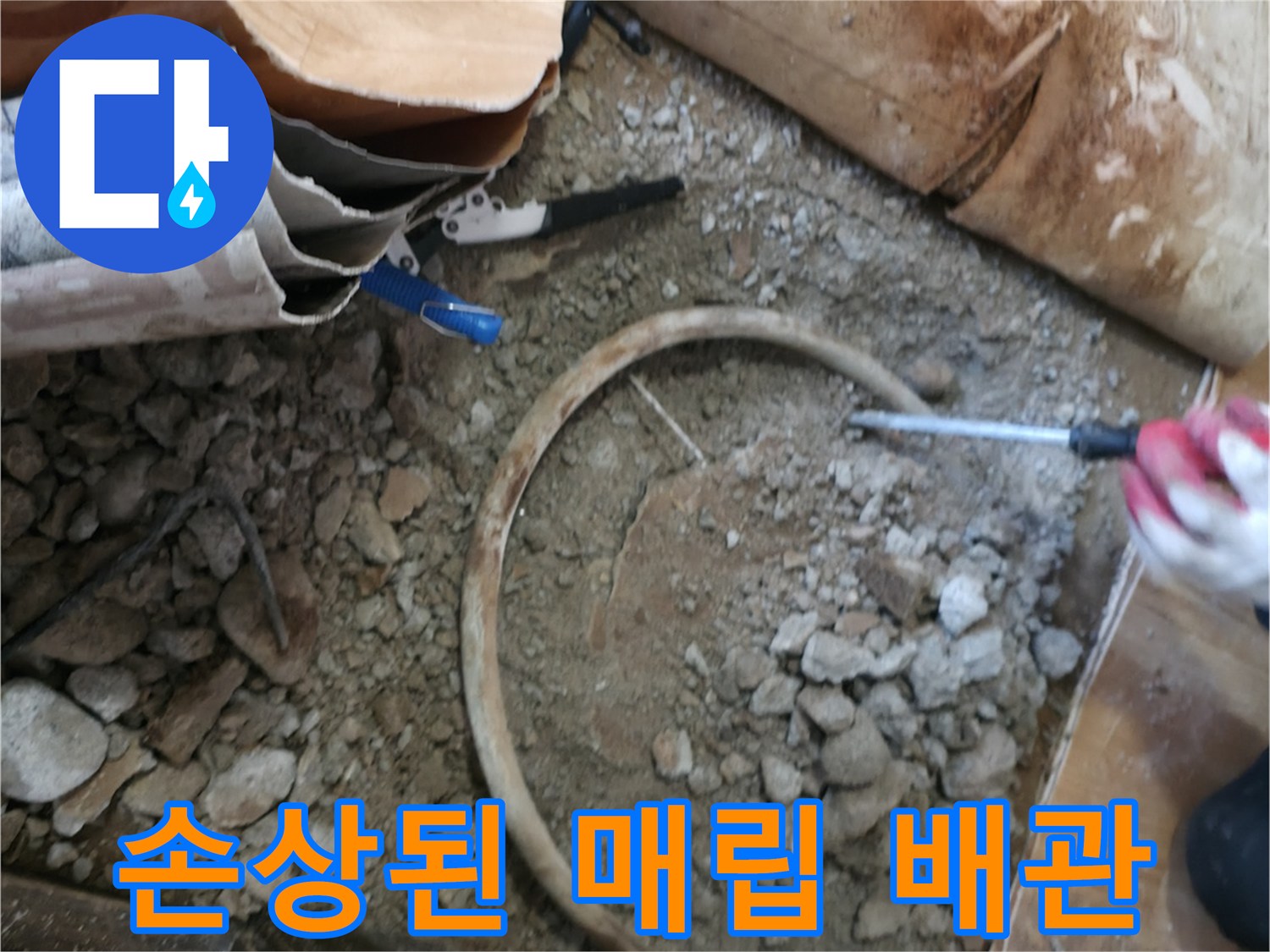 콘크리트 층 사이로 보이는 손상된 매립 배관