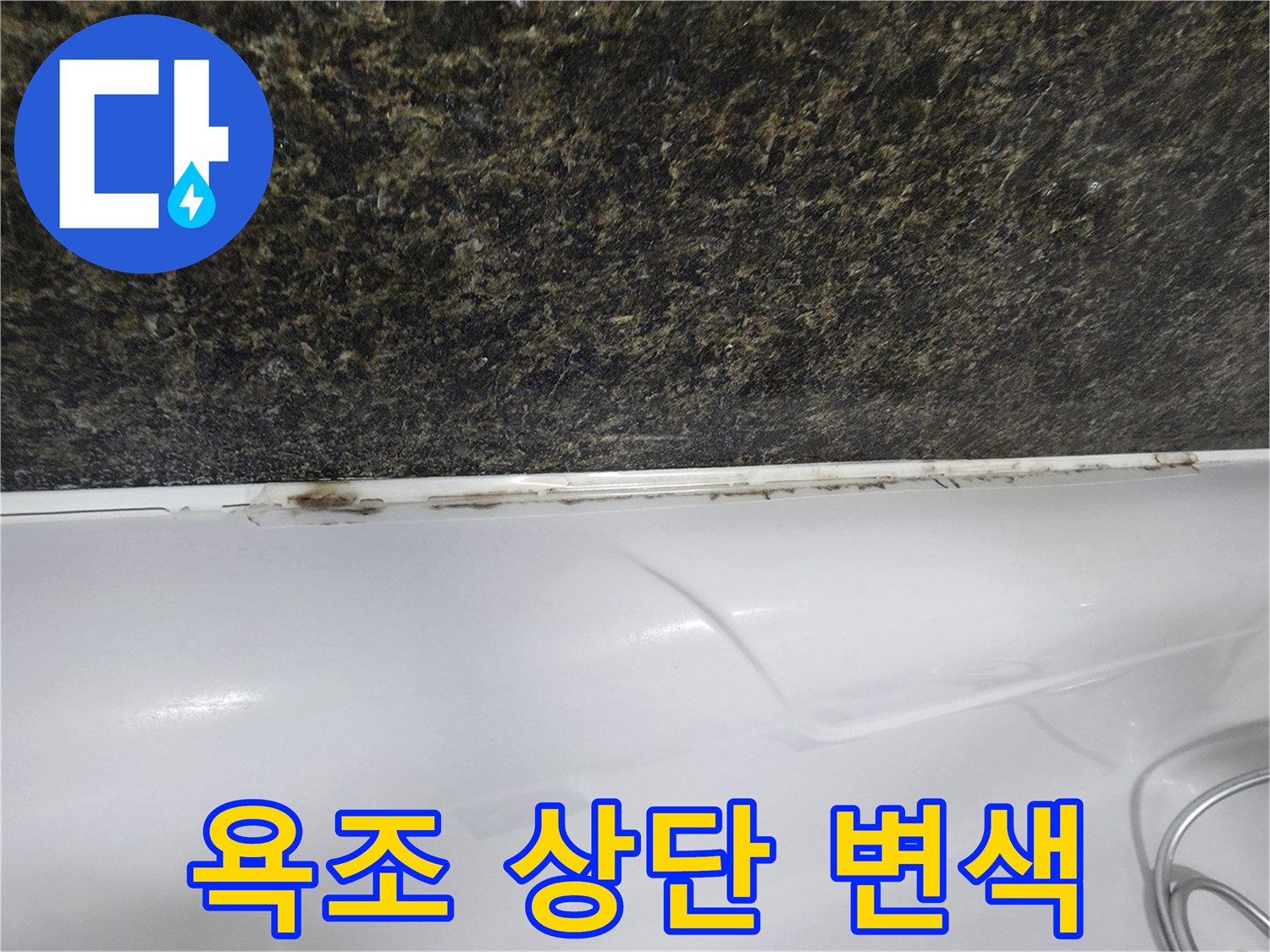 어두운 벽면재 하단의 욕조 틈새 오염 부위