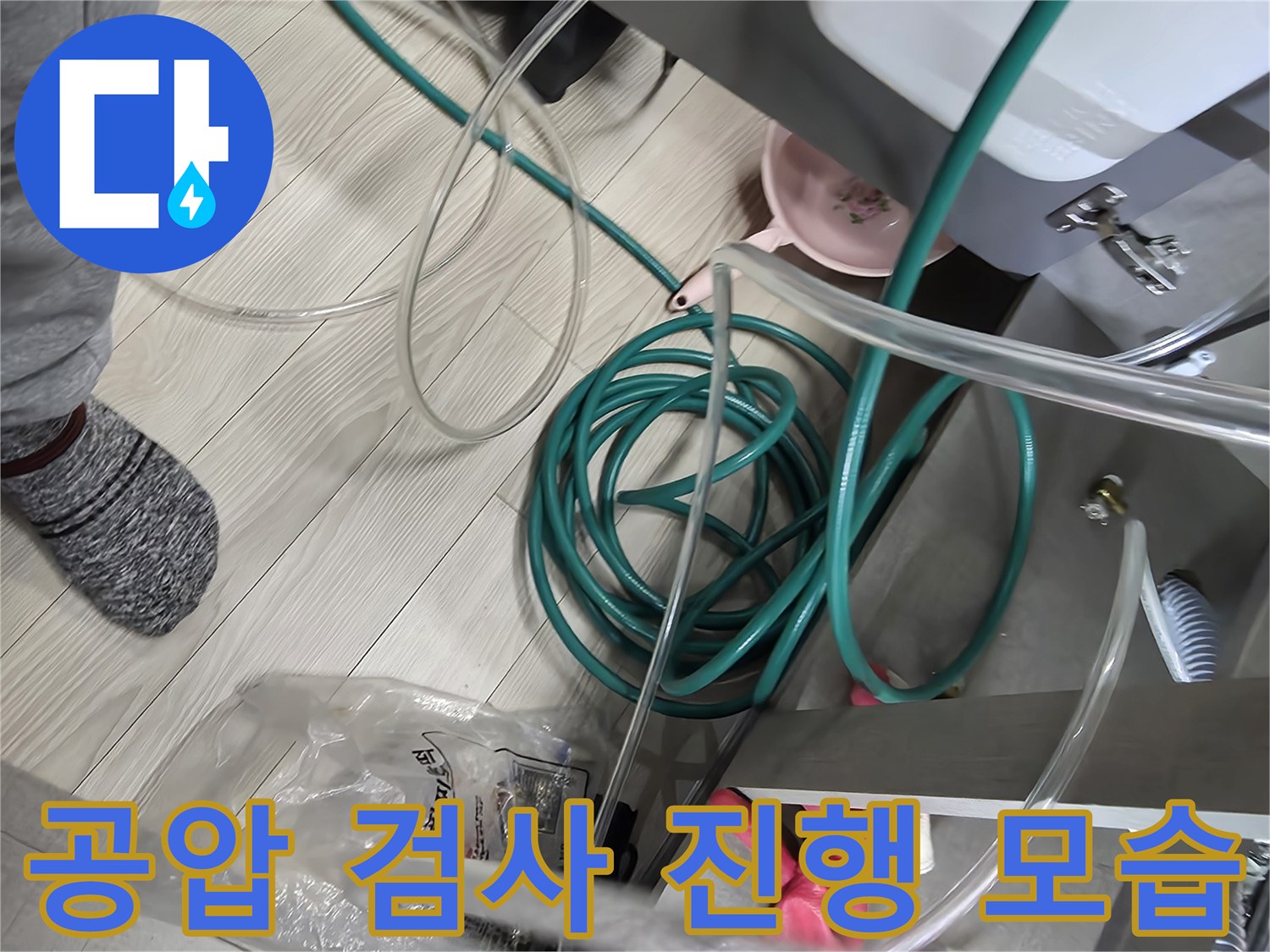 배관 연결 부위에 호스를 연결하여 압력을 측정하는 현장 상황