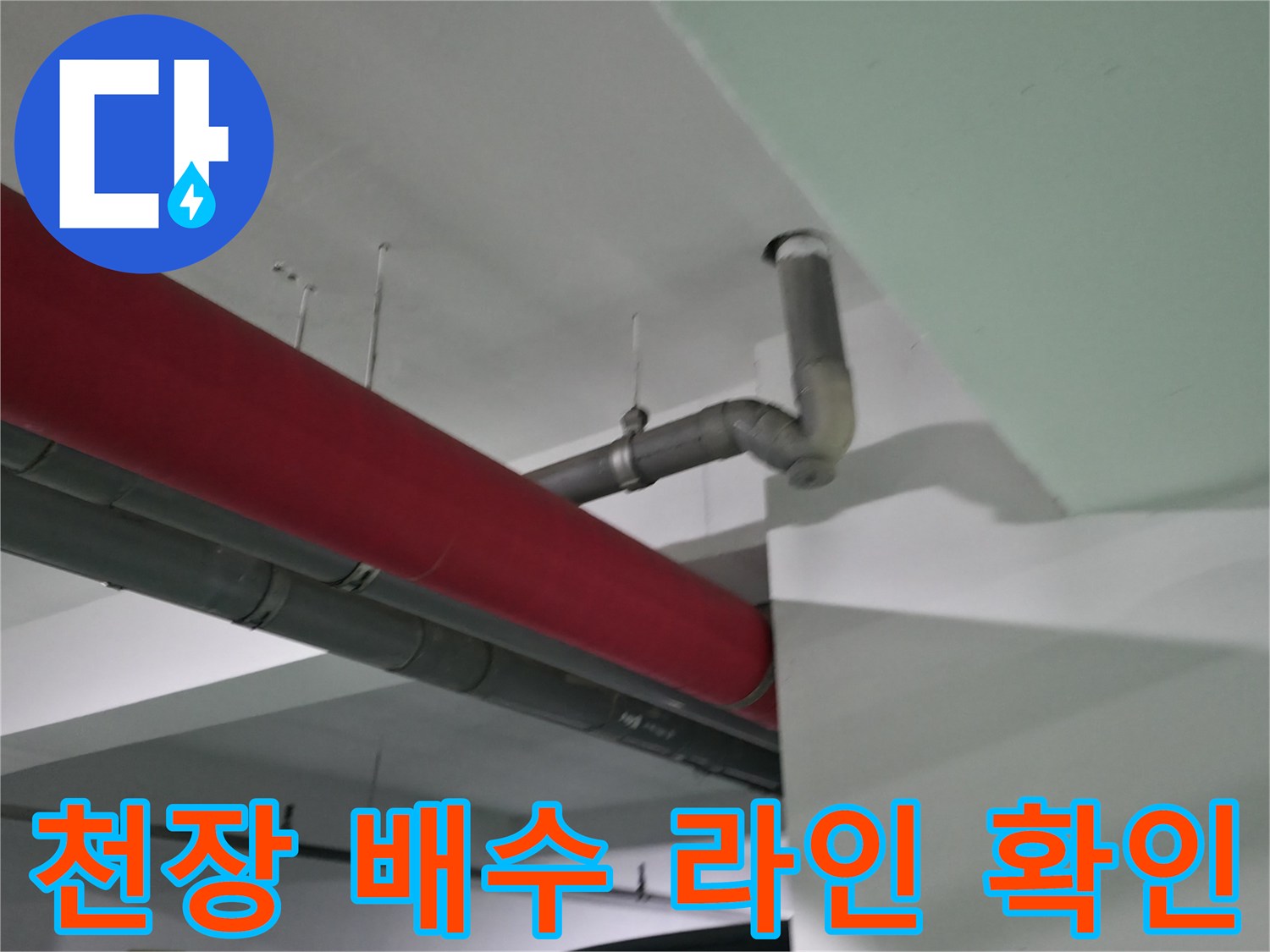 빨간색 덮개와 회색 관이 연결된 천장 안쪽의 배관 구조