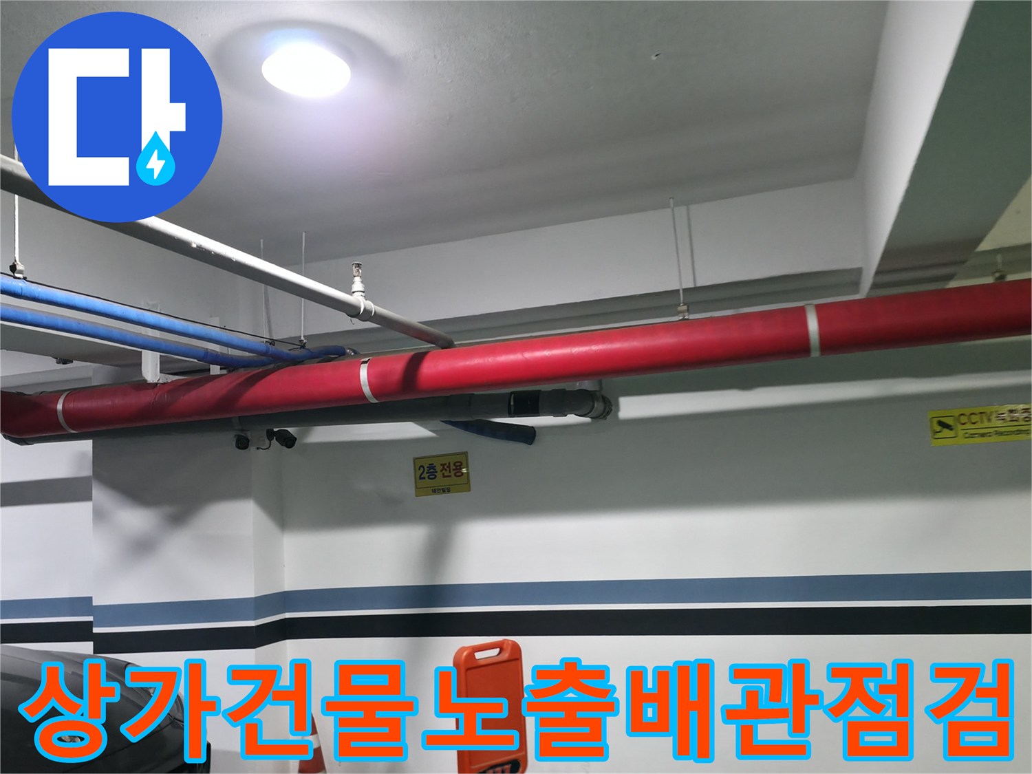 상가 건물 천장에 노출된 붉은색과 파란색 배관 시스템 점검 모습