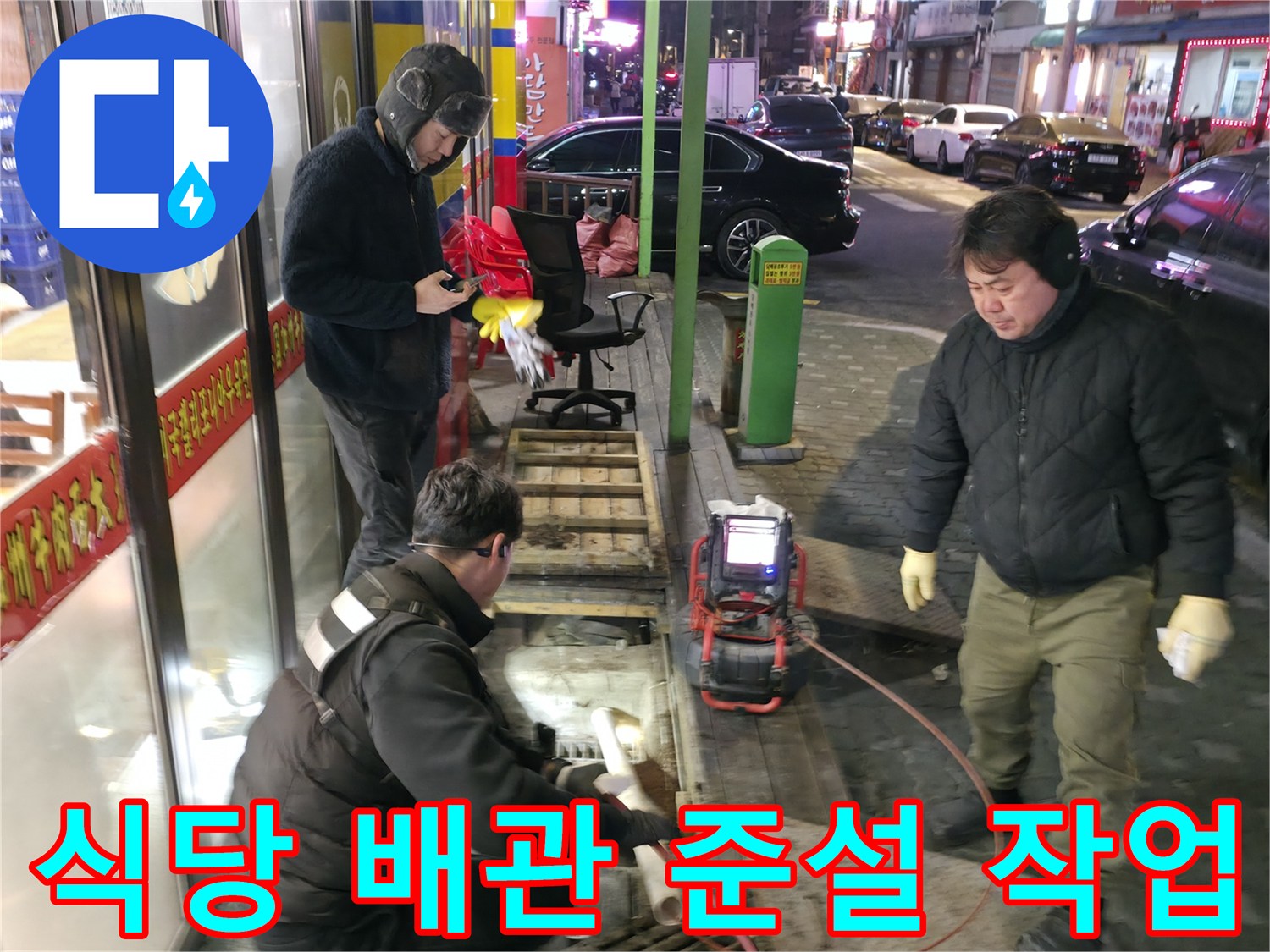 작업자가 고압 세척 장비를 활용해 식당 외부 배관을 청소하는 모습